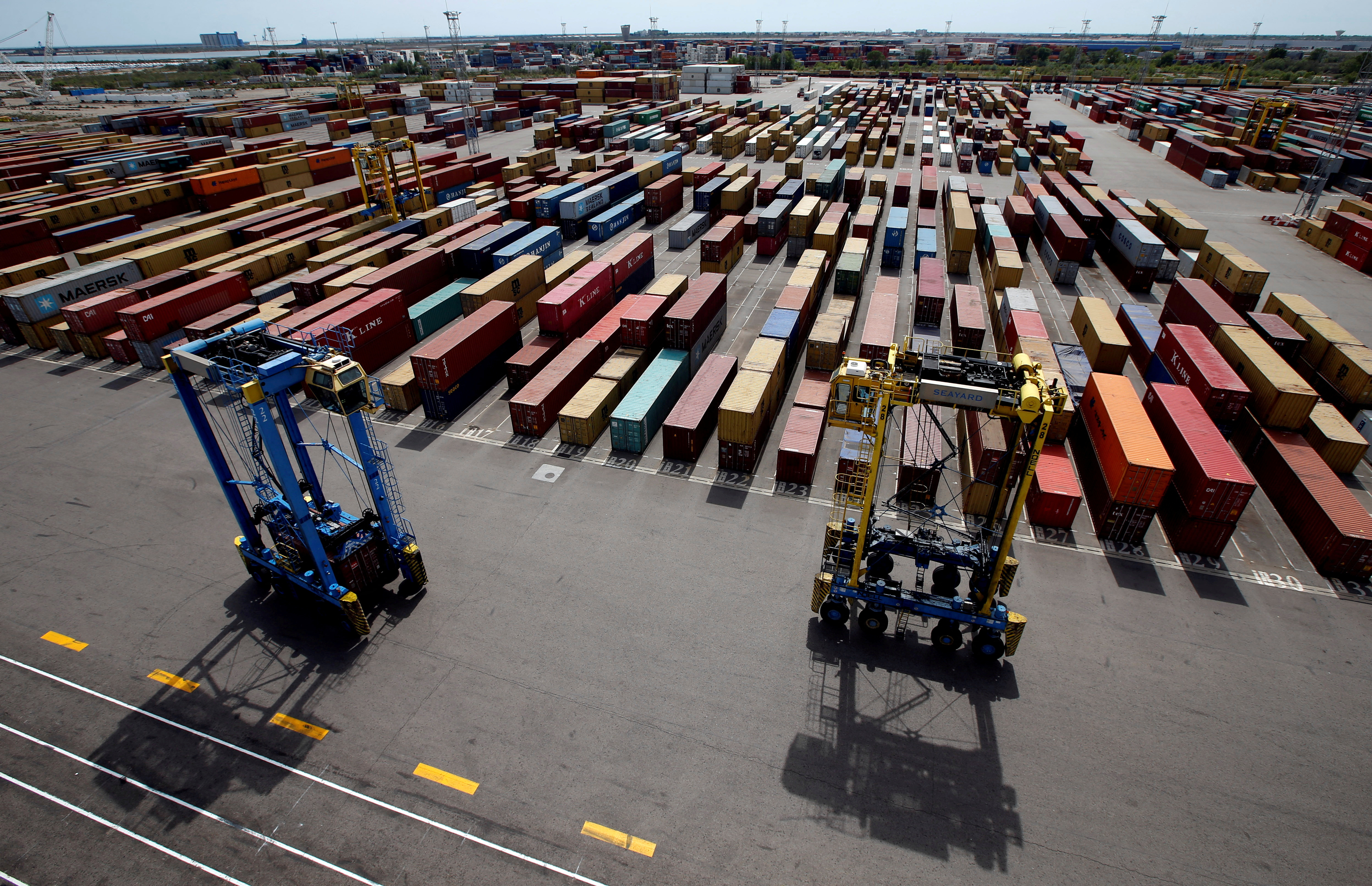 Cranes move shipping containers stacked along the dockside at the Seayard Co. terminal, operated by the Marseille-Fos port authority in Fos sur Mer