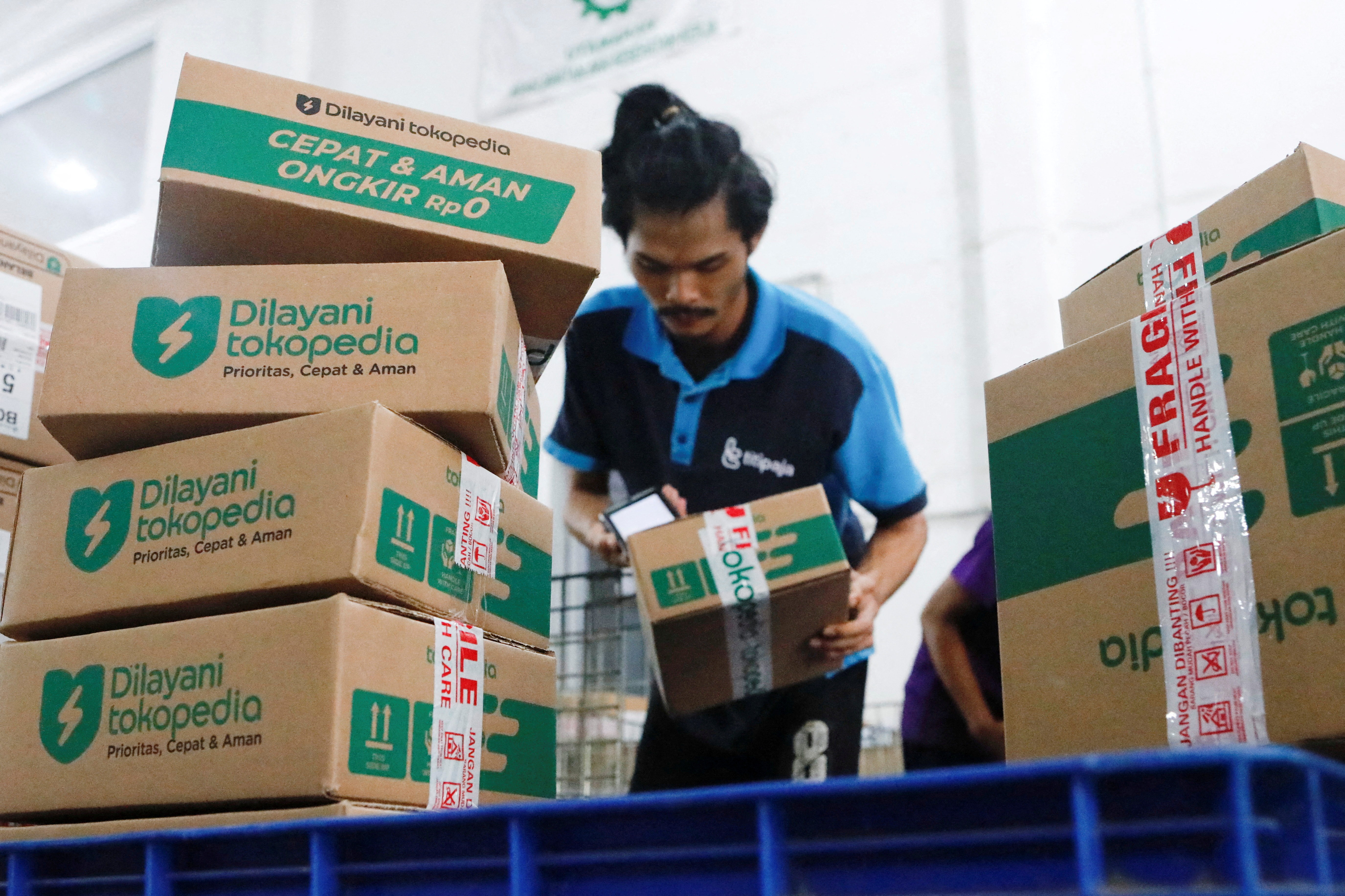 An employee packs goods at Goto's e-commerce unit Tokopedia's warehouse in Jakarta