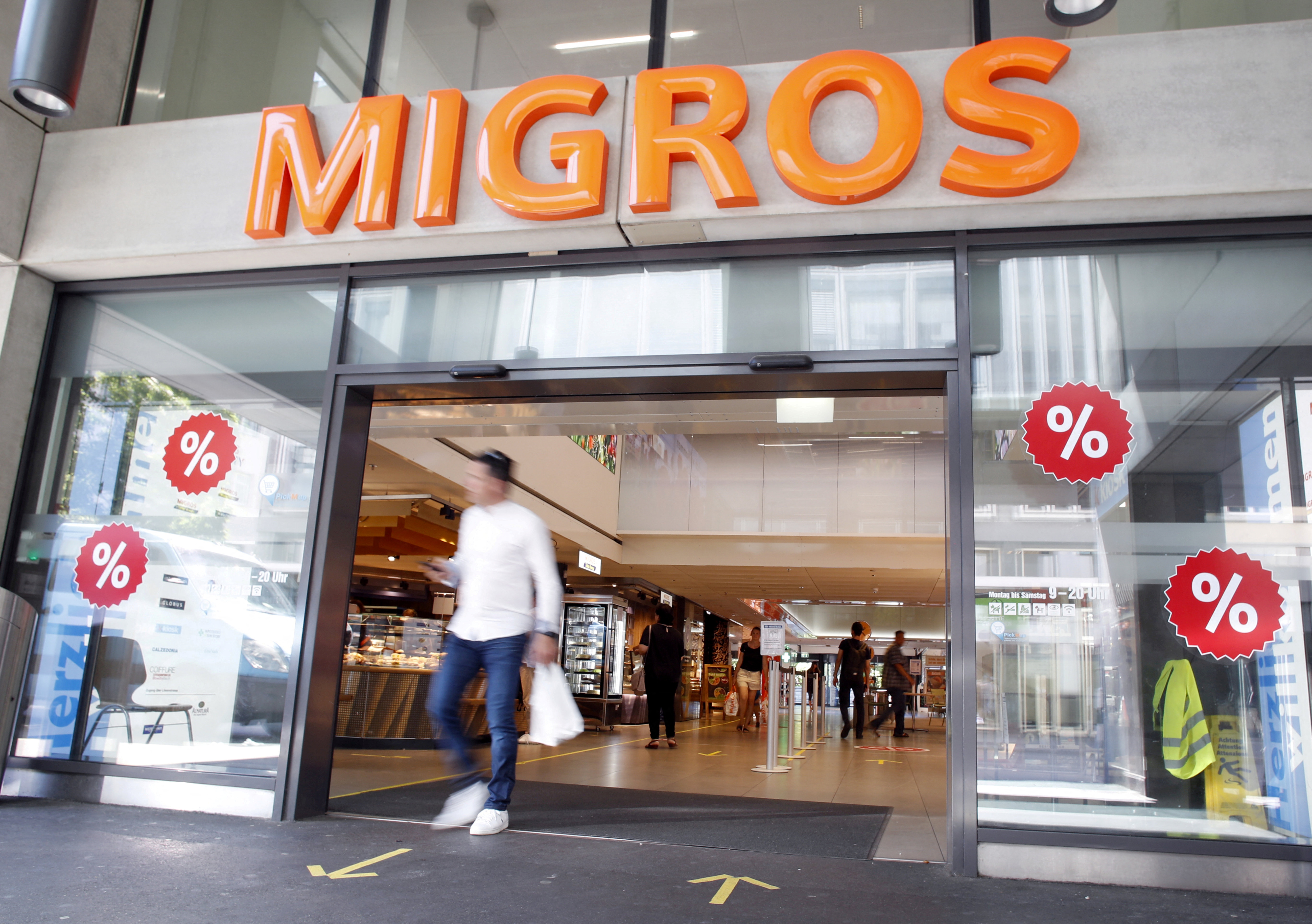 Logo is seen above the entrance of a supermarket of Swiss retail group Migros in Zurich