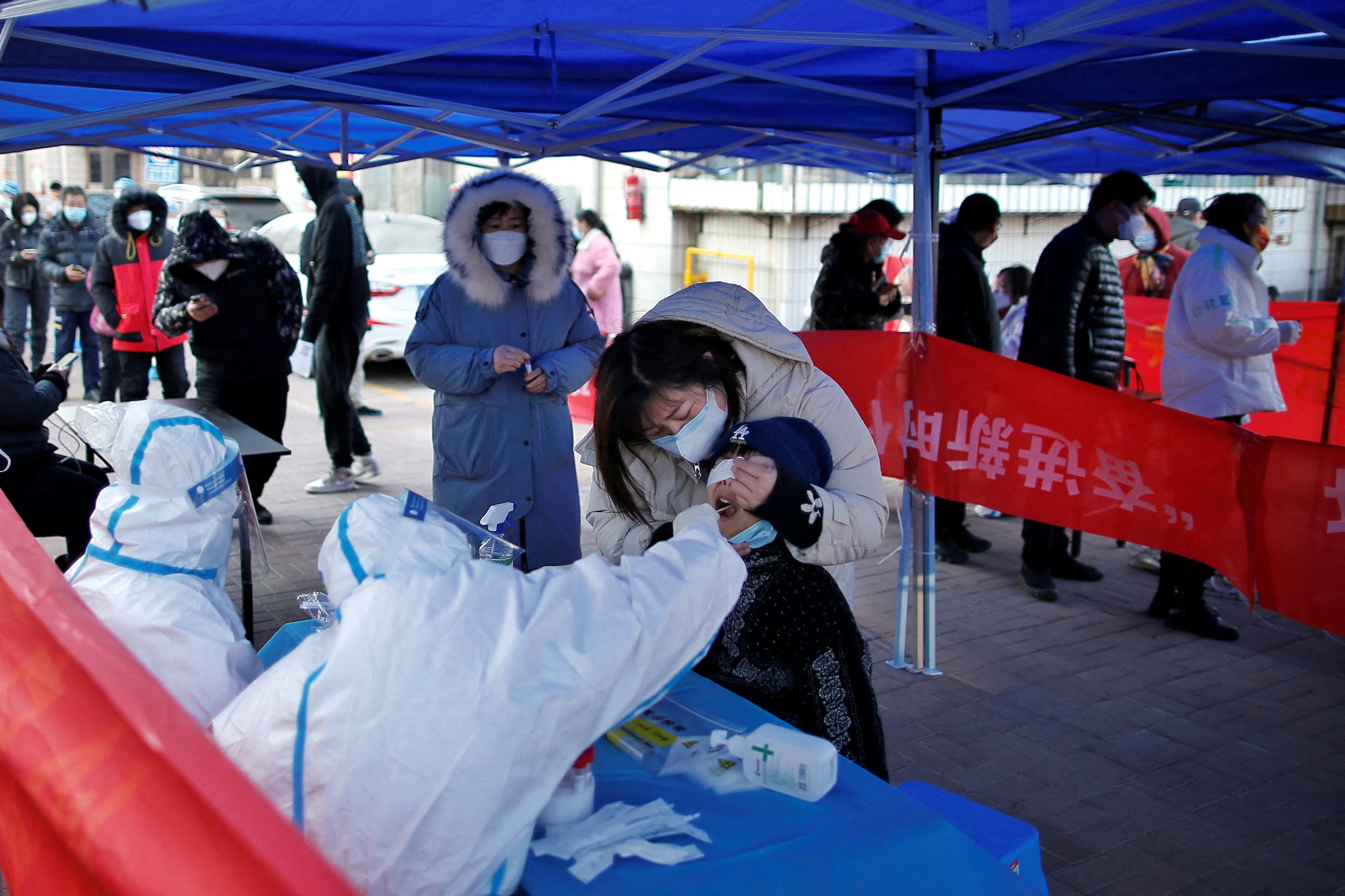 Medical worker collects a swab from a resident for nucleic acid testing in Tianjin