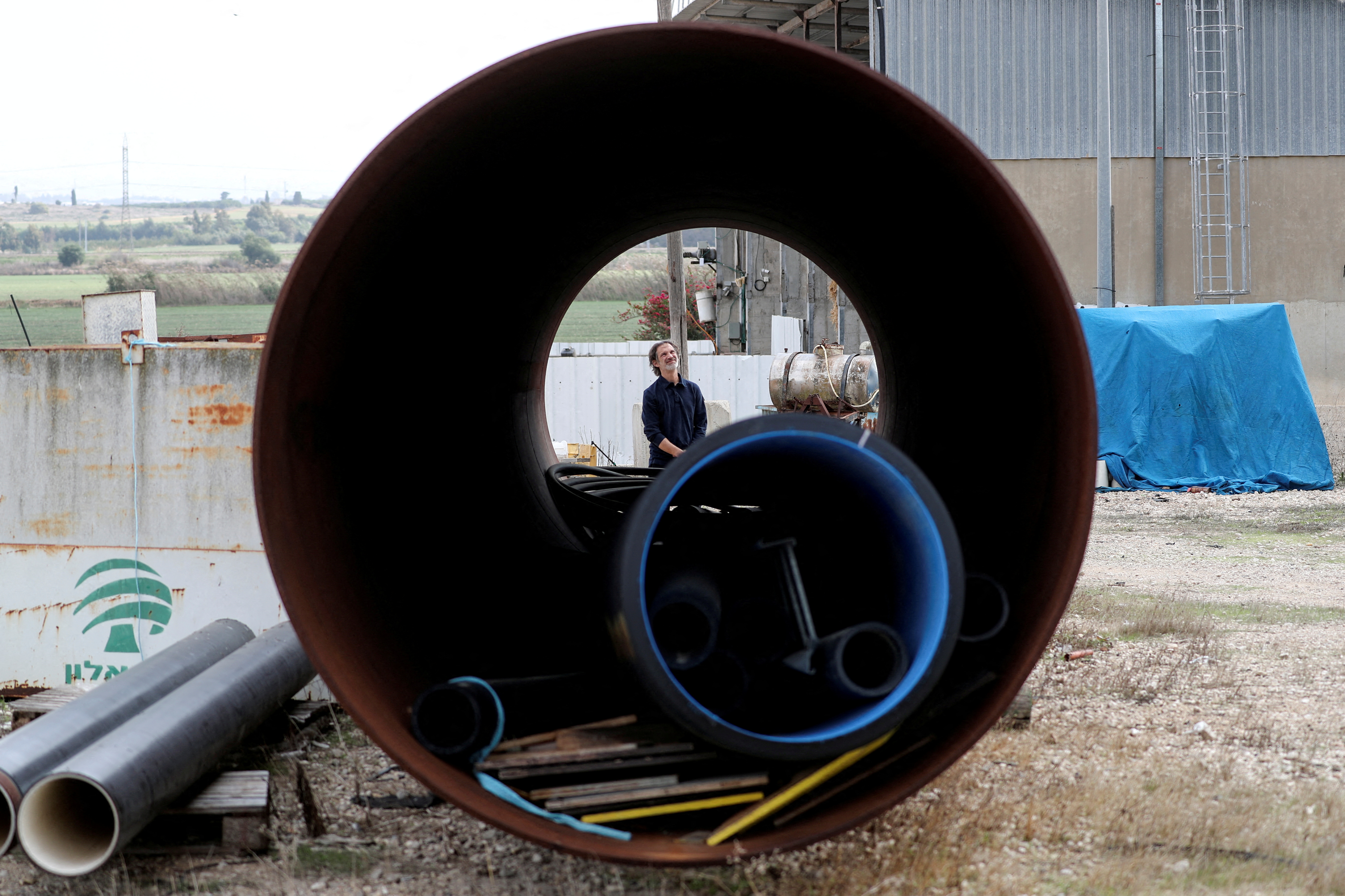 Employee looks on from behind a part of an air storage tank at Augwind's headquarters in Kibbutz Yakum, Israel