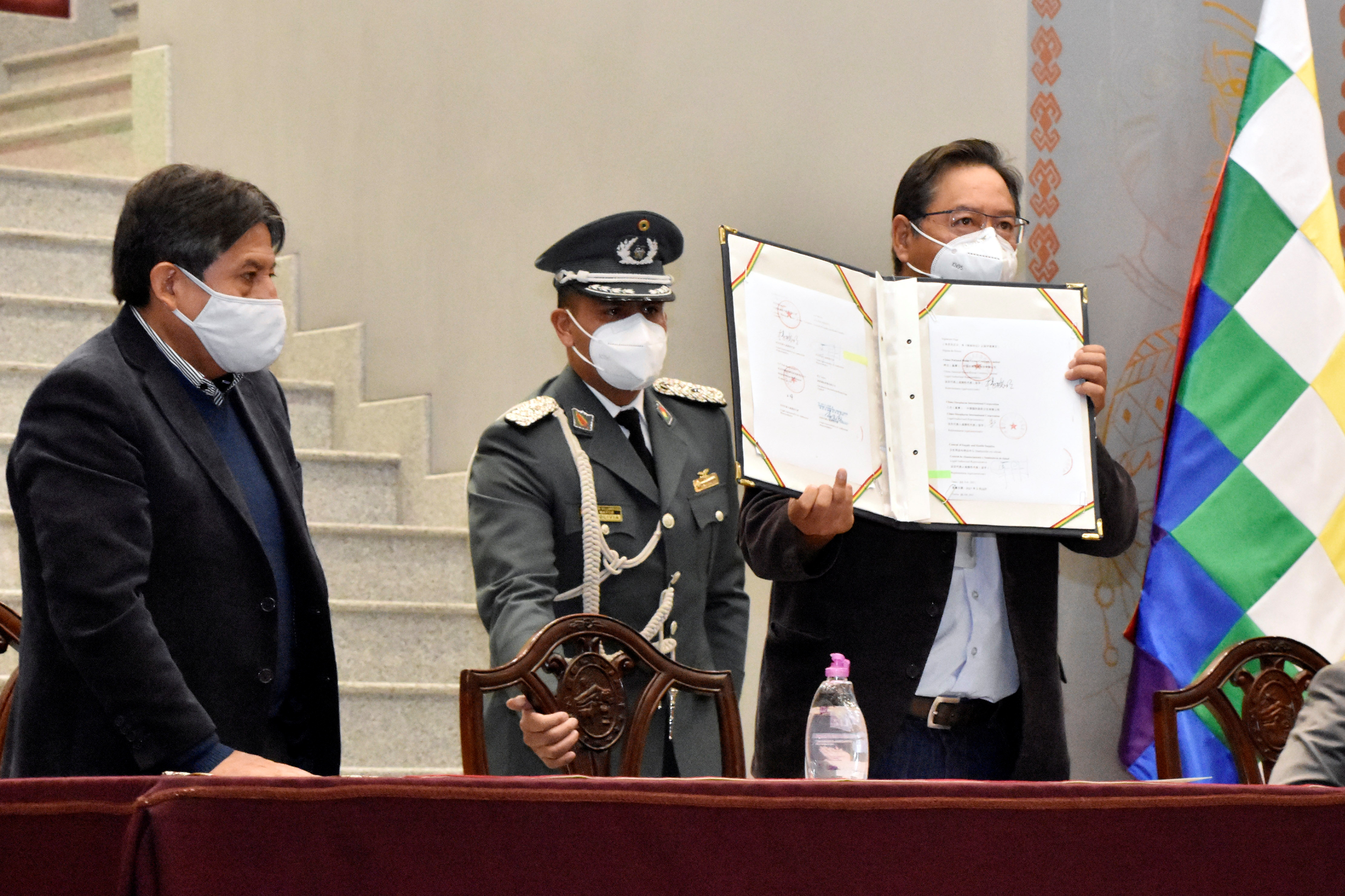 Bolivia's President Luis Arce holds the document of agreement with Chinese Sinopharm, locking in an initial supply of half a million doses of the company's vaccine against the coronavirus disease (COVID-19), as Vice President David Choquehuanca looks on at the Casa Grande del Pueblo palace in La Paz, Bolivia, February 11, 2021. Courtesy of Bolivian Presidency/Jorge Mamani/Handout via REUTERS