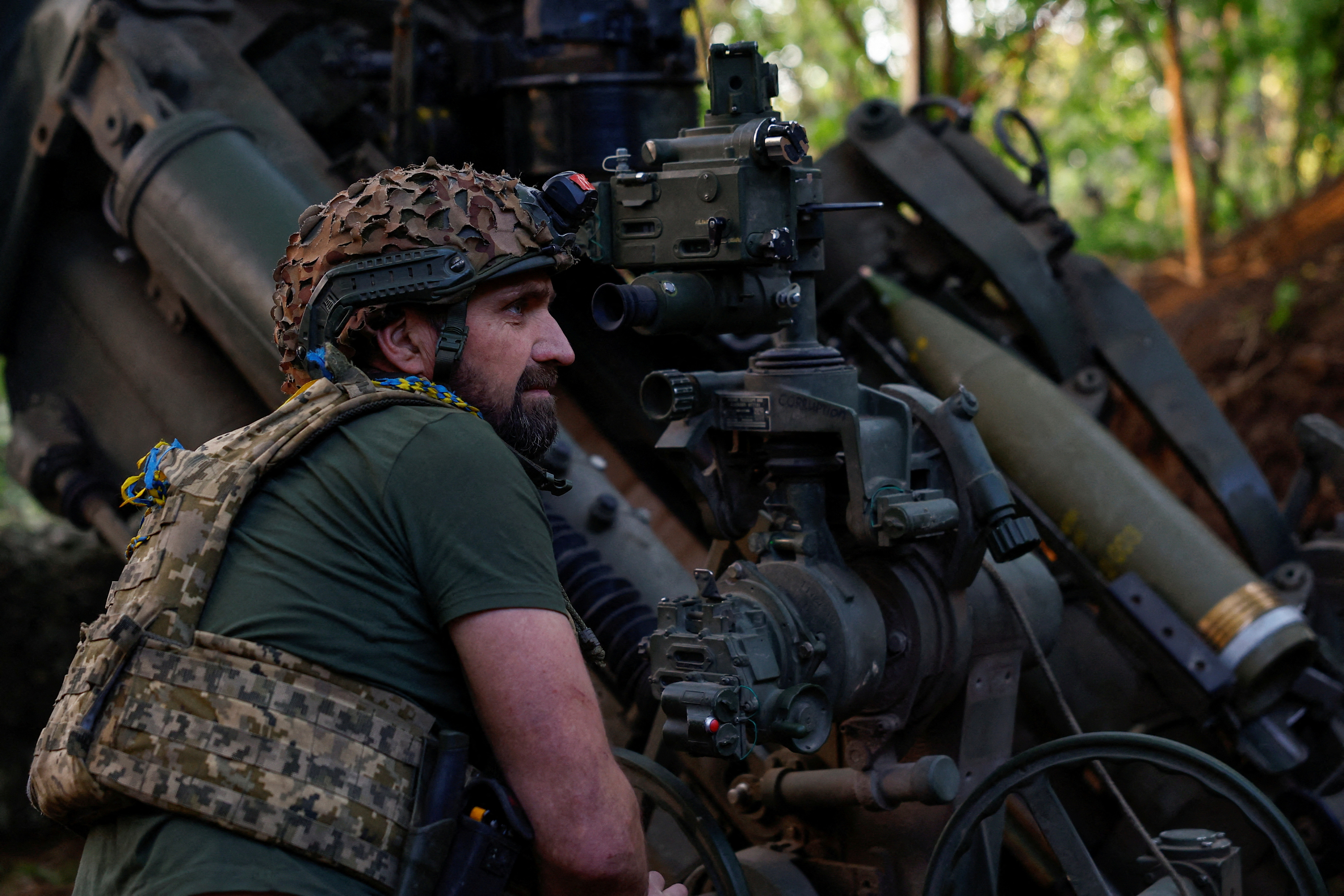 Ukrainian serviceman prepares to fire a howitzer toward Russian troops in Donetsk region