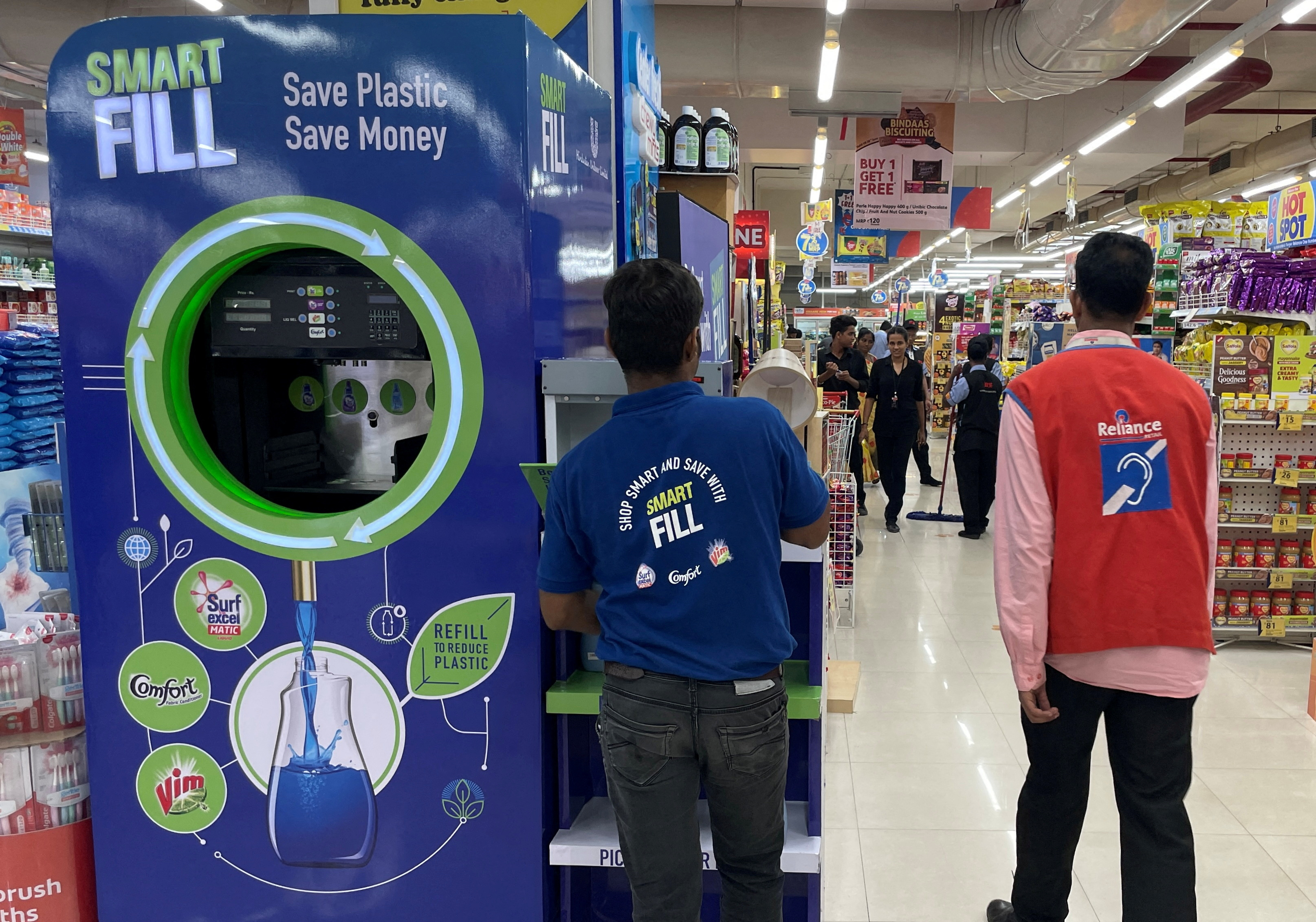 A Unilever employee removes a bottle from a 'Smart Fill' refilling machine inside a supermarket in Mumbai