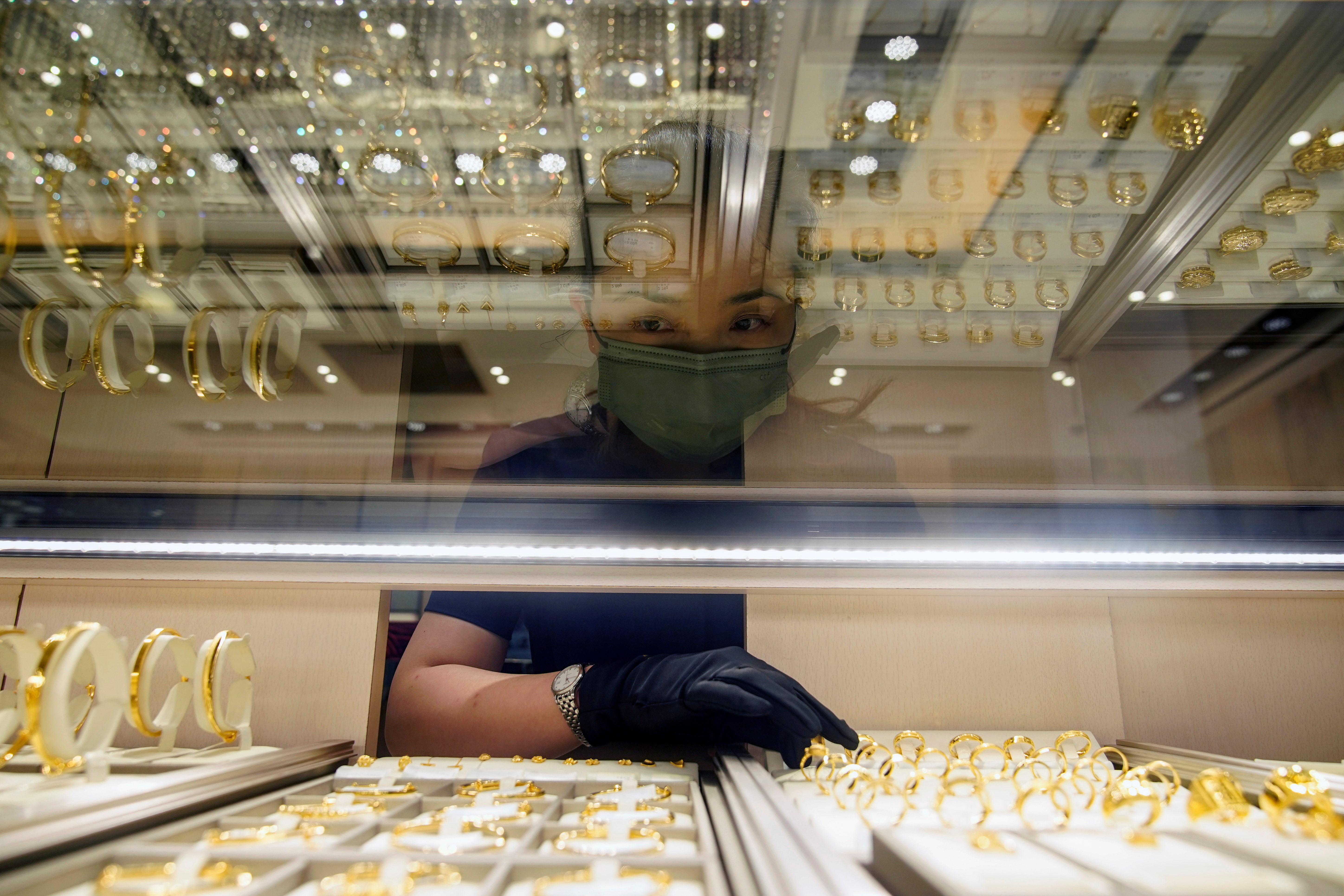 A salesperson poses with gold jewellery at jeweller Chow Tai Fook’s retail store in Shanghai