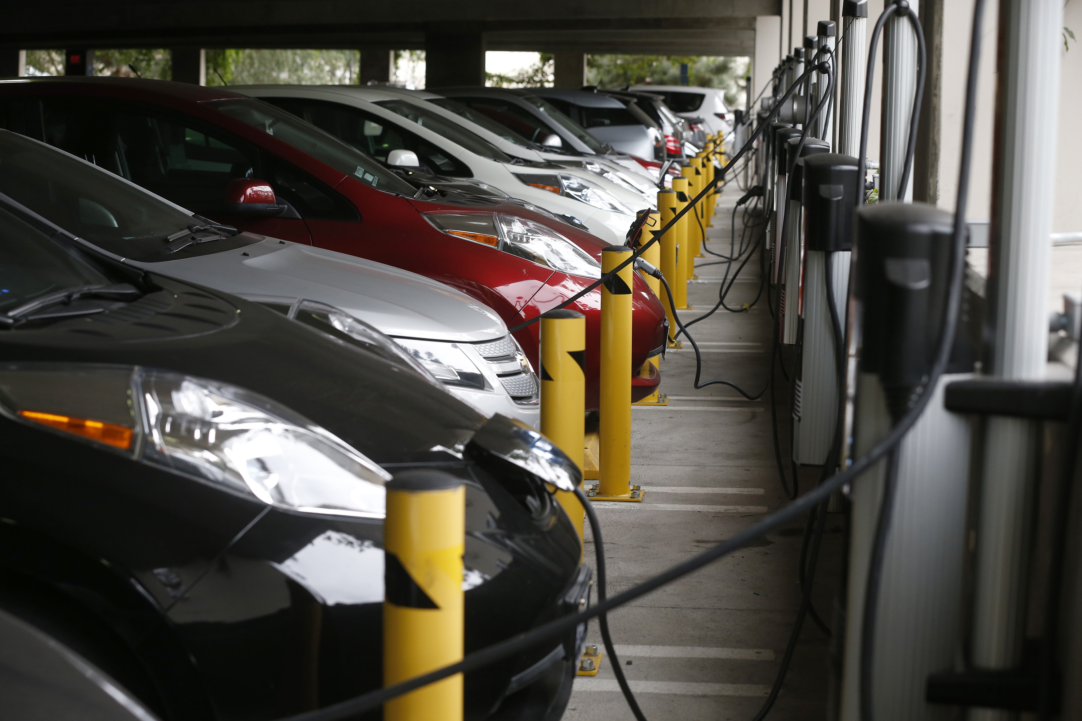 Electric cars sit charging in a parking garage at the University of California, Irvine