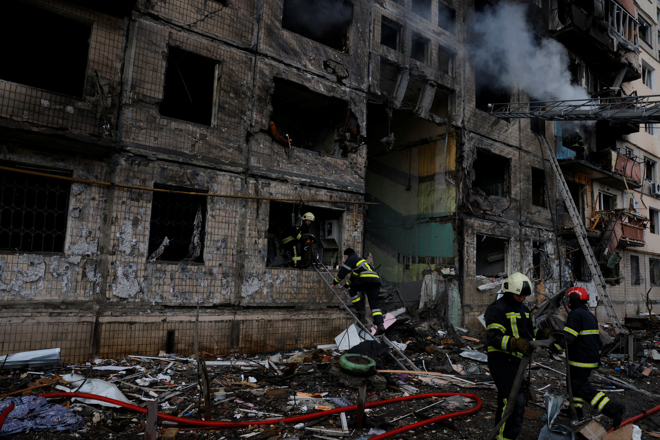 Firefighters work to extinguish a fire in a residential building that was hit by a shell in the Obolon district in Kyiv