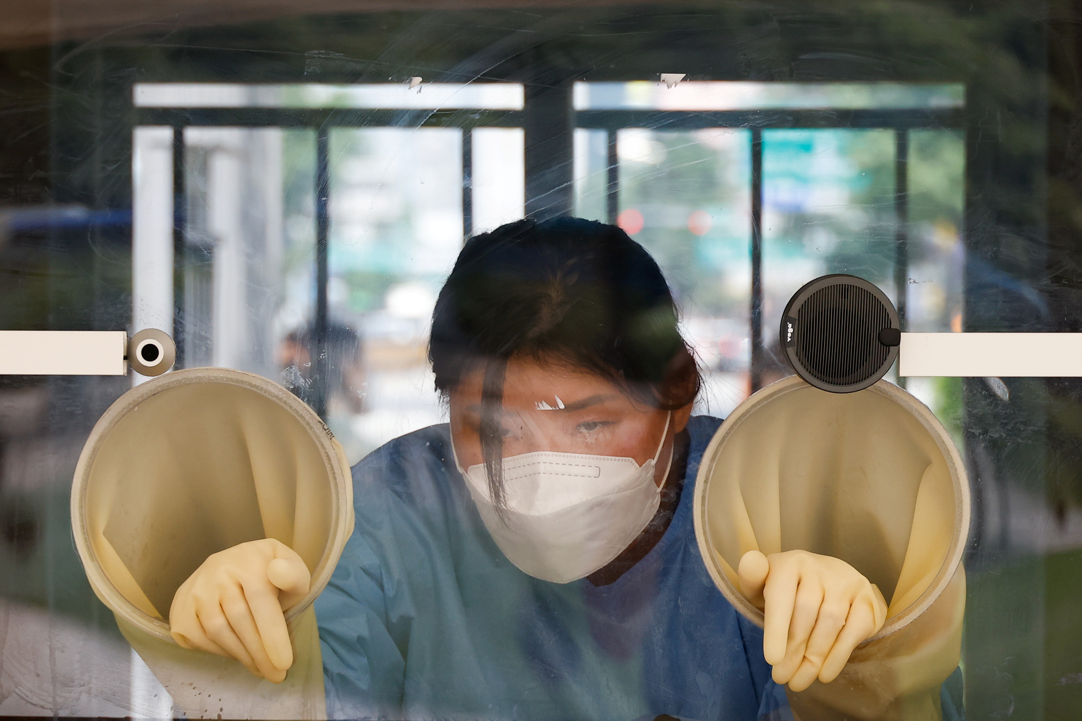 A health worker rests inside a booth as she conducts a coronavirus disease (COVID-19) test at a coronavirus testing site in Seoul