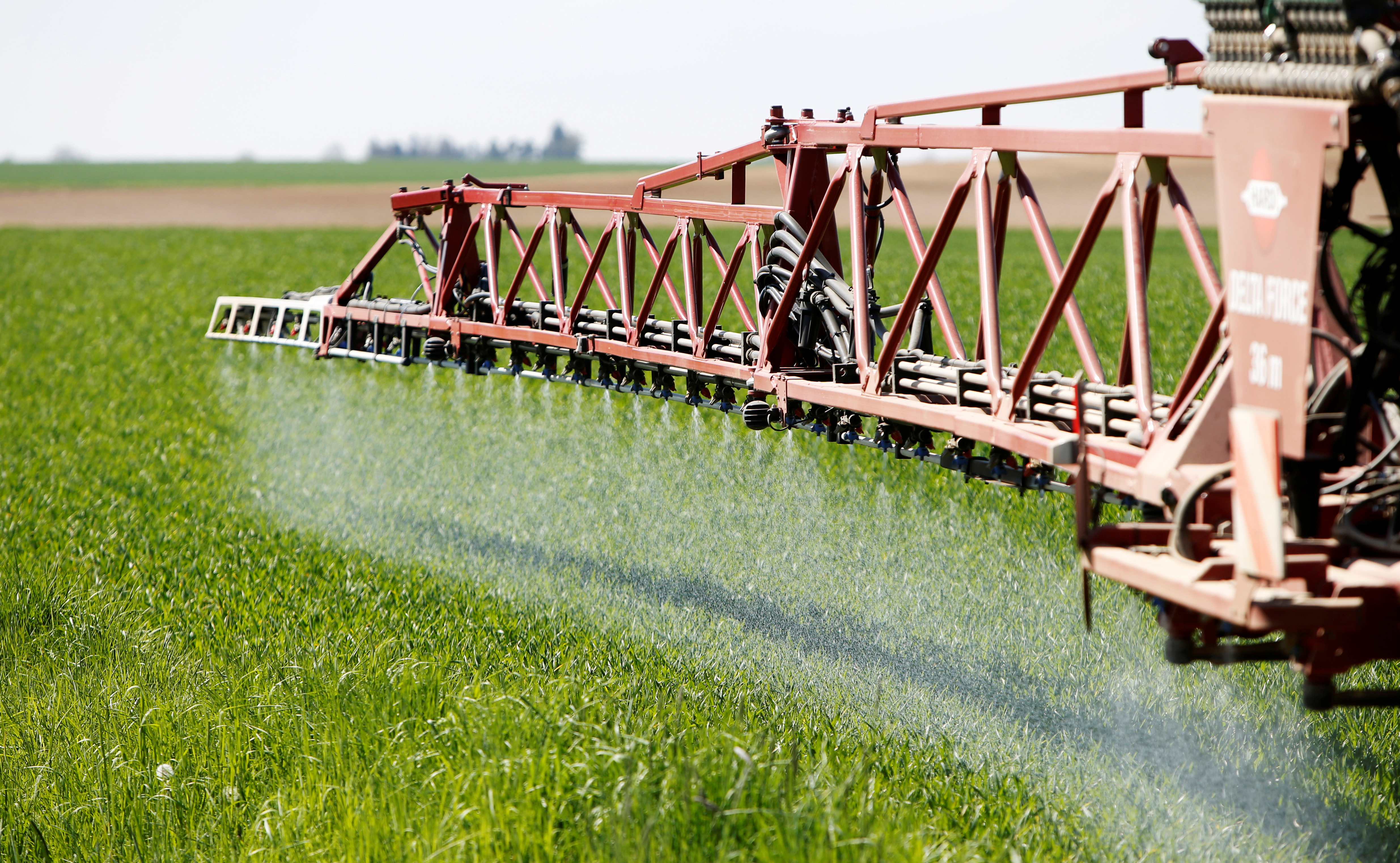 A tractor applies liquid nitrogen fertilizer to a wheat field in Irlbach