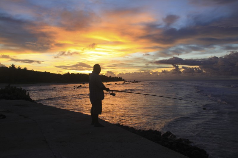 A fisherman is pictured at sunset at the northern end of the airport runway on the nation island of Nauru