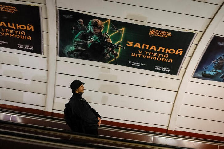 Banner advertising military service in the Ukrainian Armed Forces is seen at a metro station in Kyiv