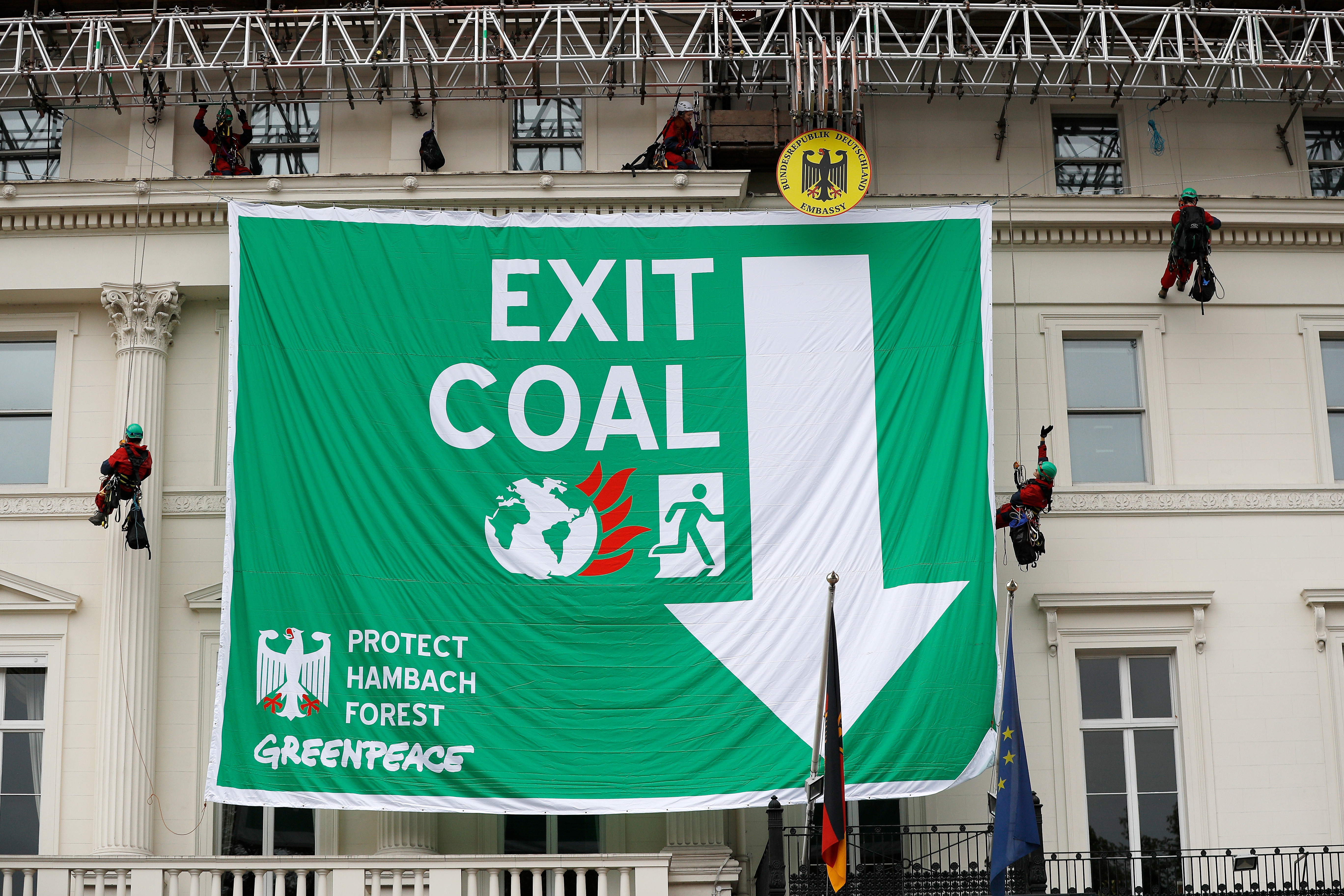 Greenpeace activists abseil down the facade of Germany's embassy as they unfurl a banner against coal, in London