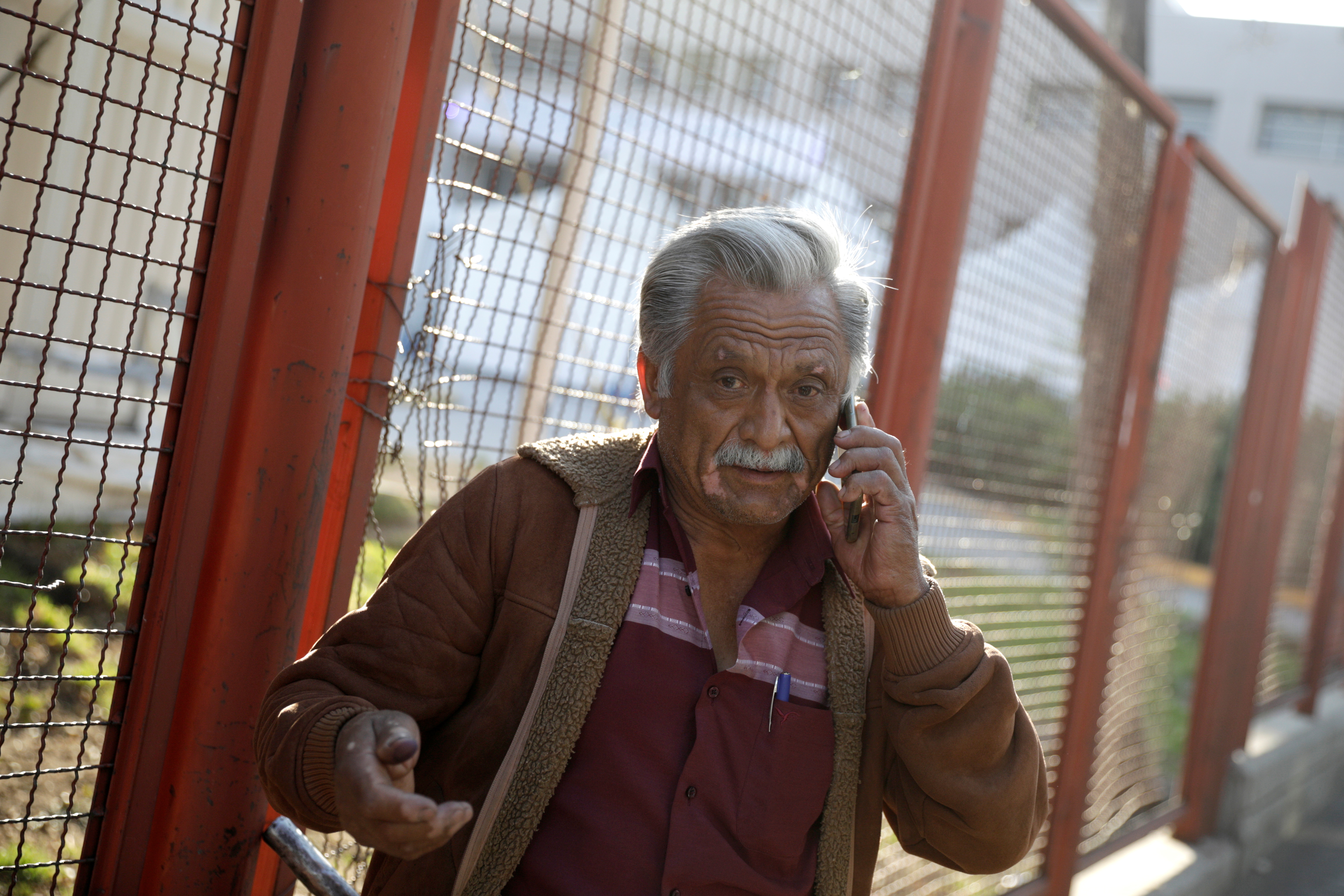 Jorge Hernandez speaks on the phone while waiting for news about his 28-year-old nephew Daniel, who had been seriously injured during the accident where an overpass of a metro partially collapsed with train cars on it, outside a hospital in Mexico City, Mexico May 4, 2021. REUTERS/Luis Cortes