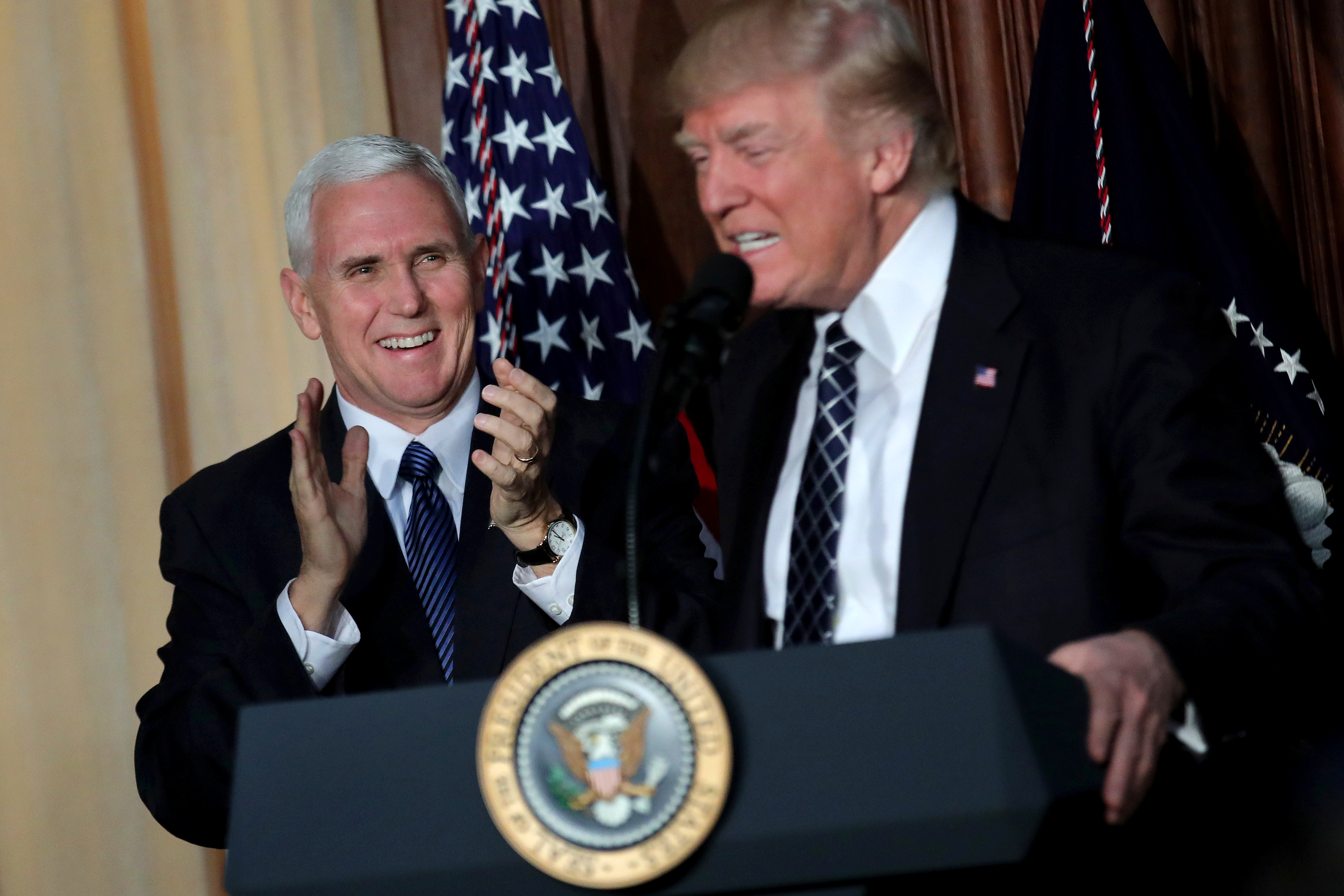 U.S. President Donald Trump reacts as he is introduced by Vice President Mike Pence during the signing of an executive order on 