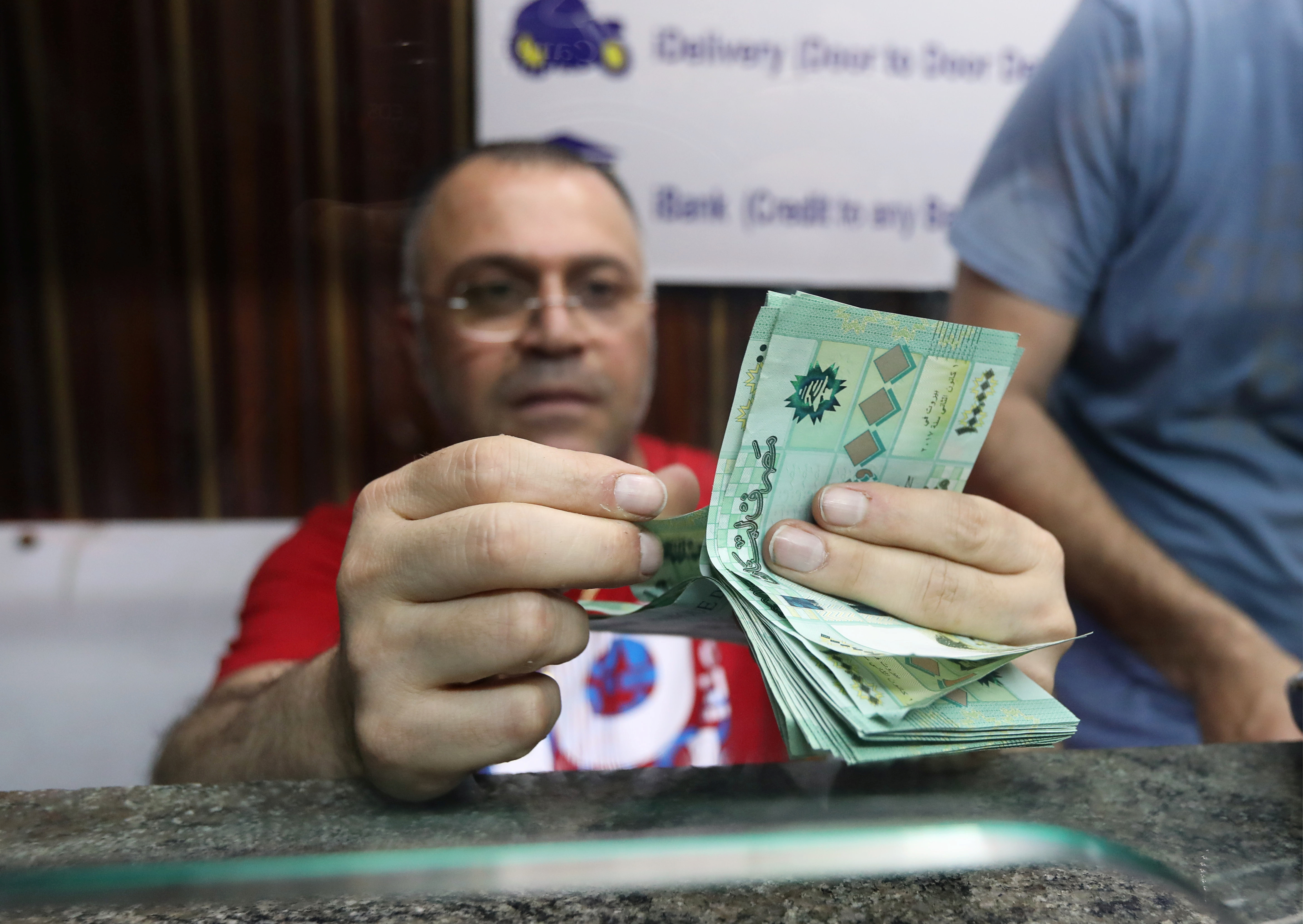 A money exchange vendor counts Lebanese pound banknotes at a currency exchange shop in Beirut