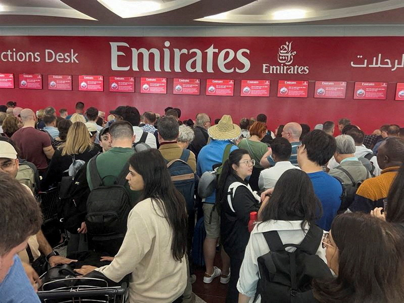 People queue at a flight connection desk after a rainstorm hit Dubai, causing delays at the Dubai International Airport