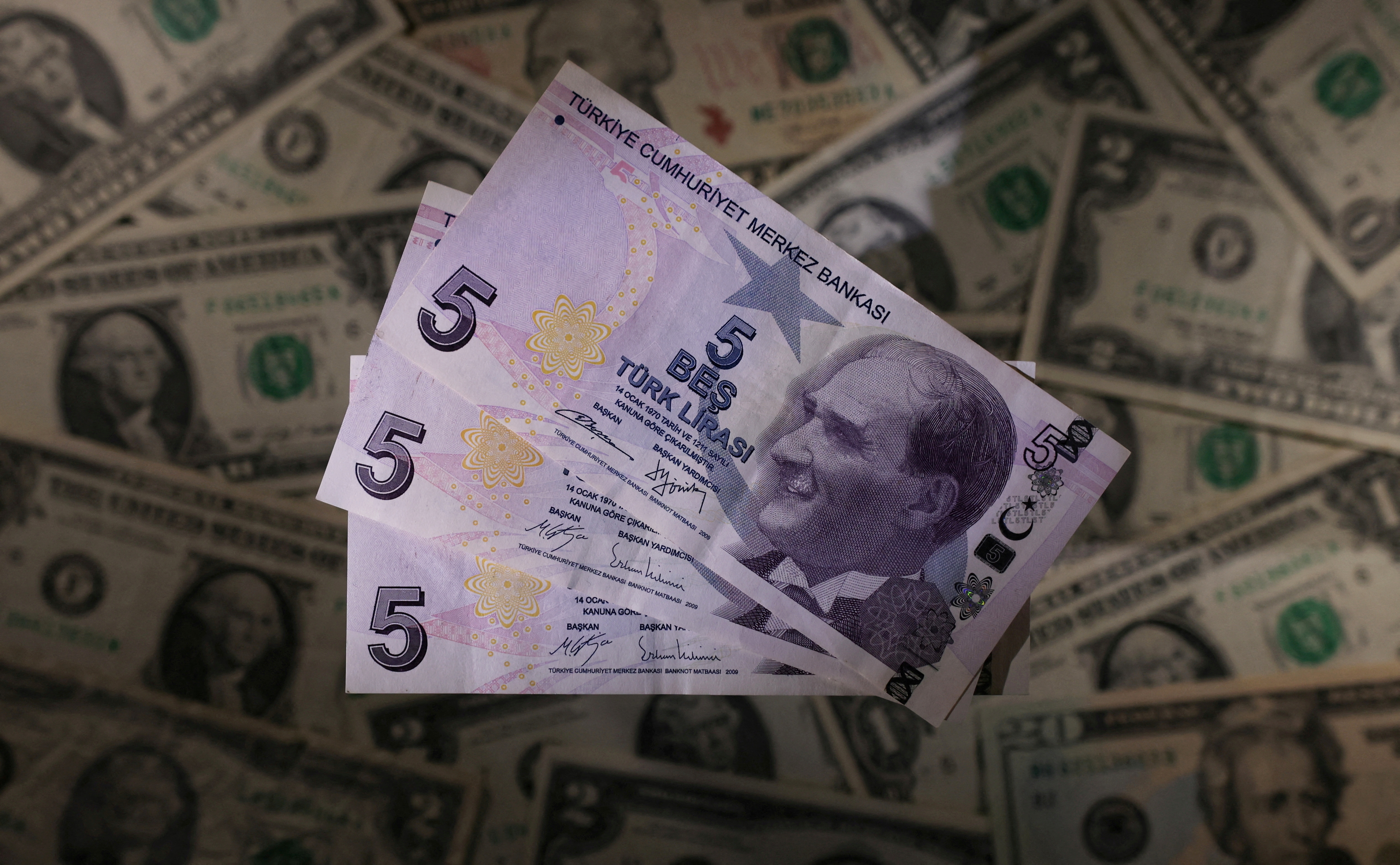 Turkish lira banknotes are seen placed on U.S. Dollar banknotes in this illustration