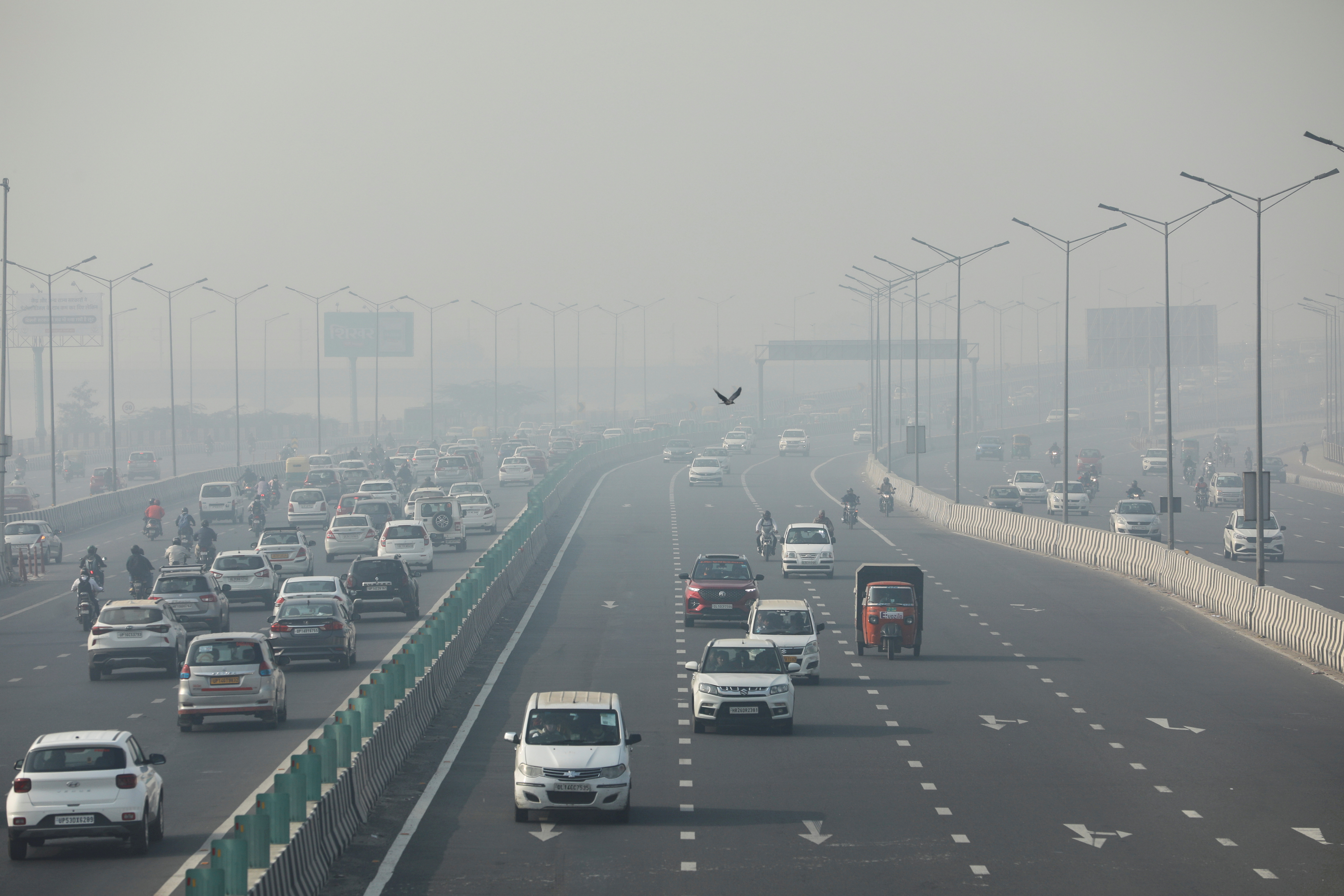 Vehicles are seen shrouded in smog on a highway in New Delhi, India