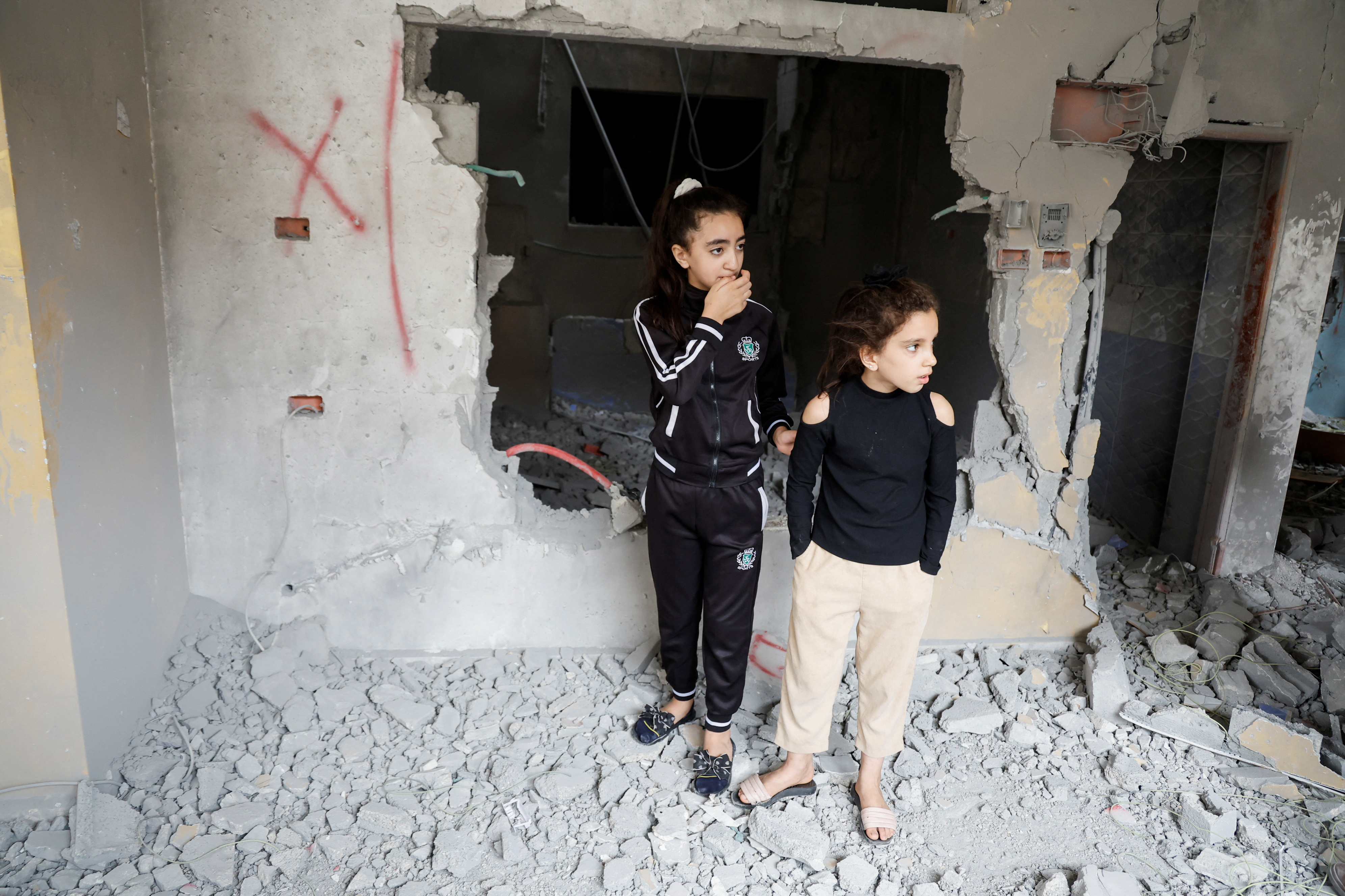 Palestinian children react as they check the damage after Israeli troops demolished the house of a Palestinian assailant in Askar refugee camp near Nablus