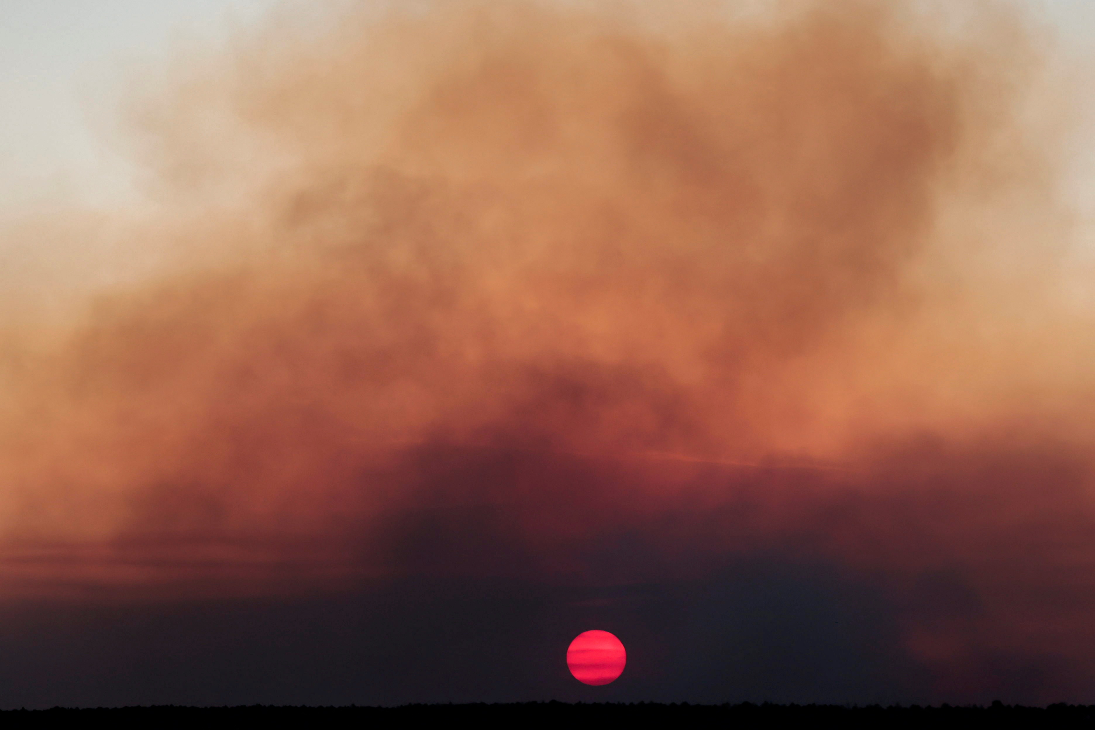 Sun appears through smoke rising from a wildfire in an area of Brasilia's National Forest in Brasilia