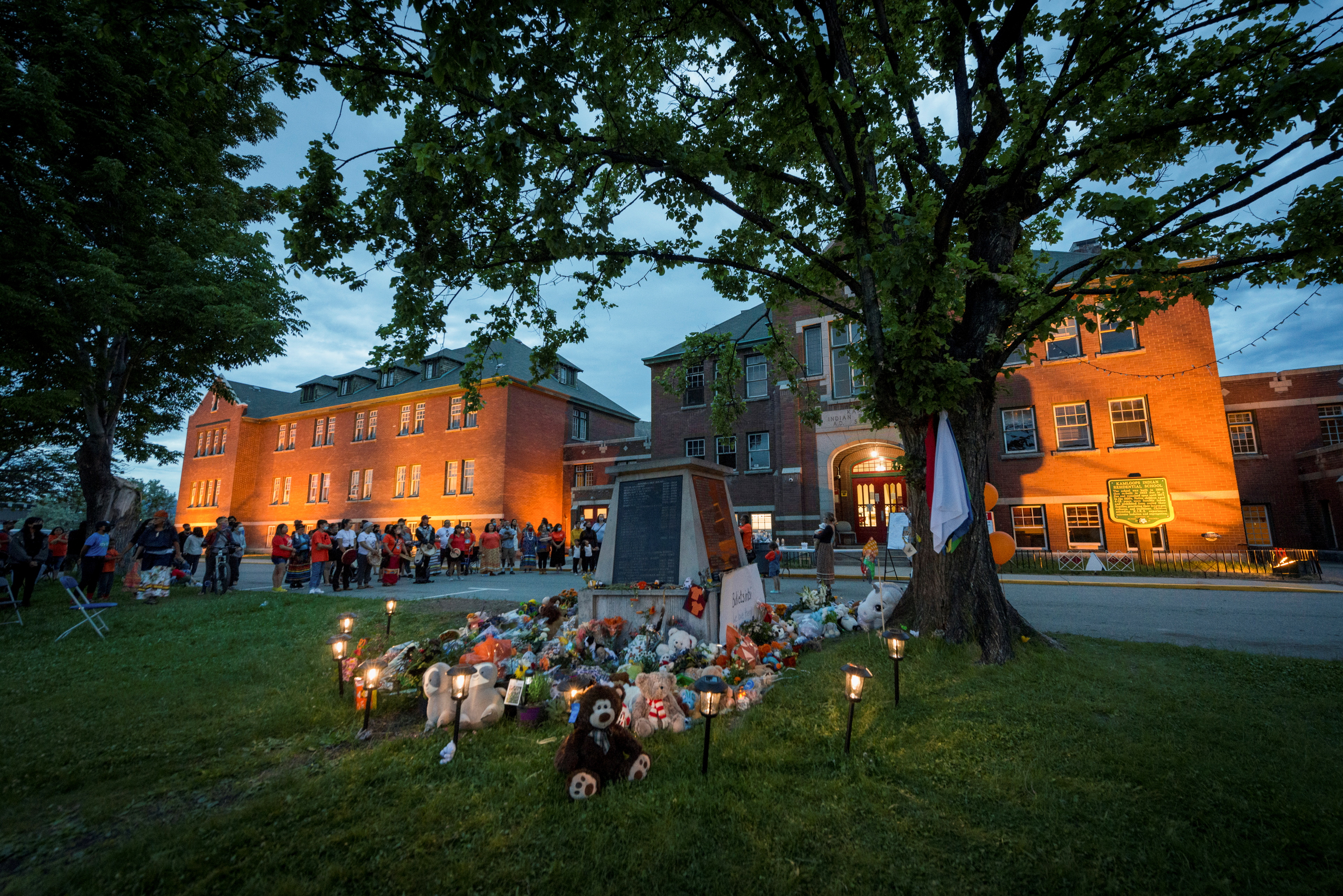 Kamloops residents and First Nations people gather to listen to drummers and singers at a memorial in front of the former Kamloops Indian Residential School after the remains of 215 children, some as young as three years old, were found at the site last week, in Kamloops, British Columbia, Canada May 31, 2021. REUTERS/Dennis Owen