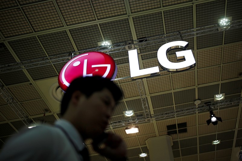 A man talking on his phone walks past the logo of LG Electronics during Korea Electronics Show 2016 in Seoul