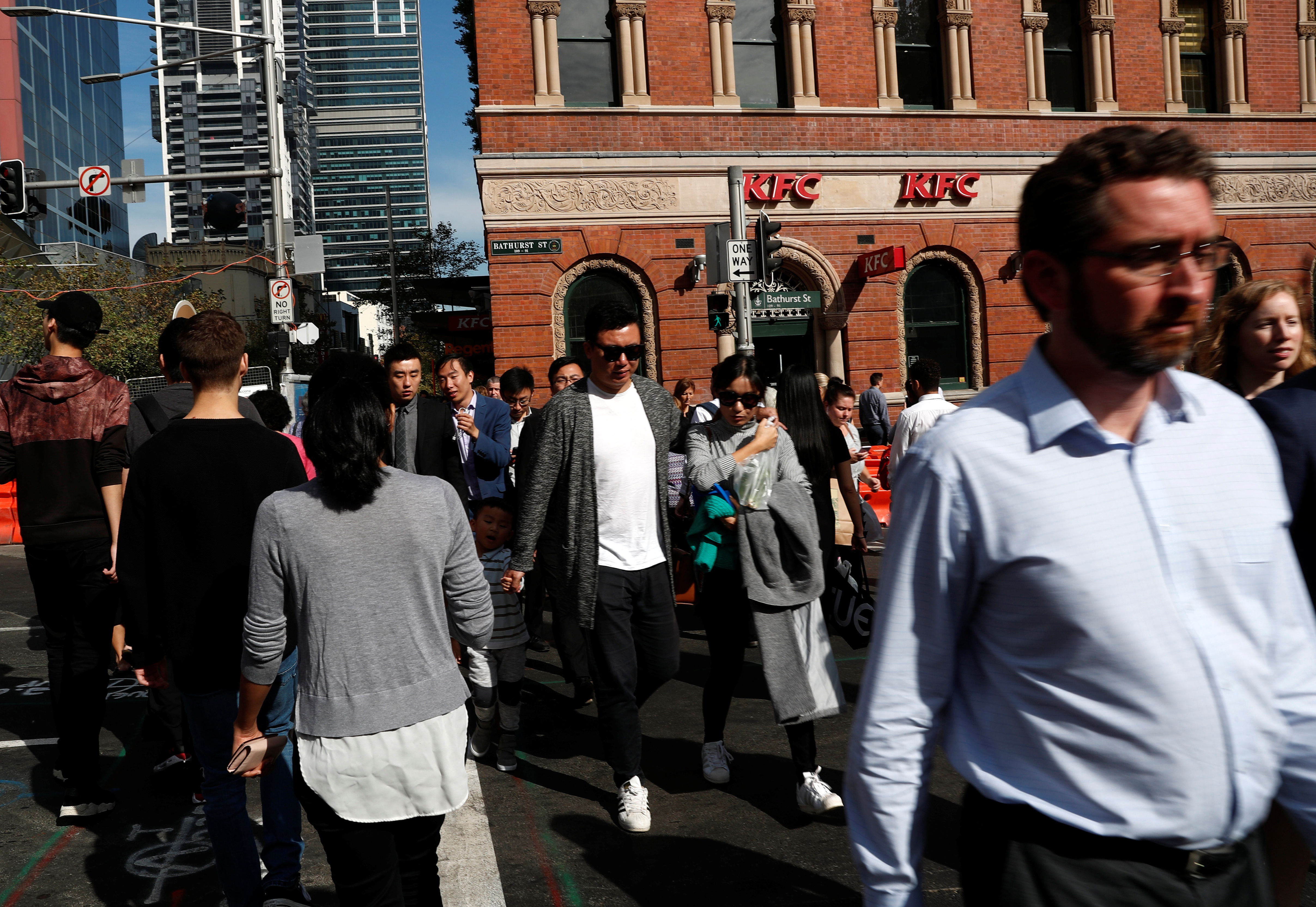 People cross a street in Sydney