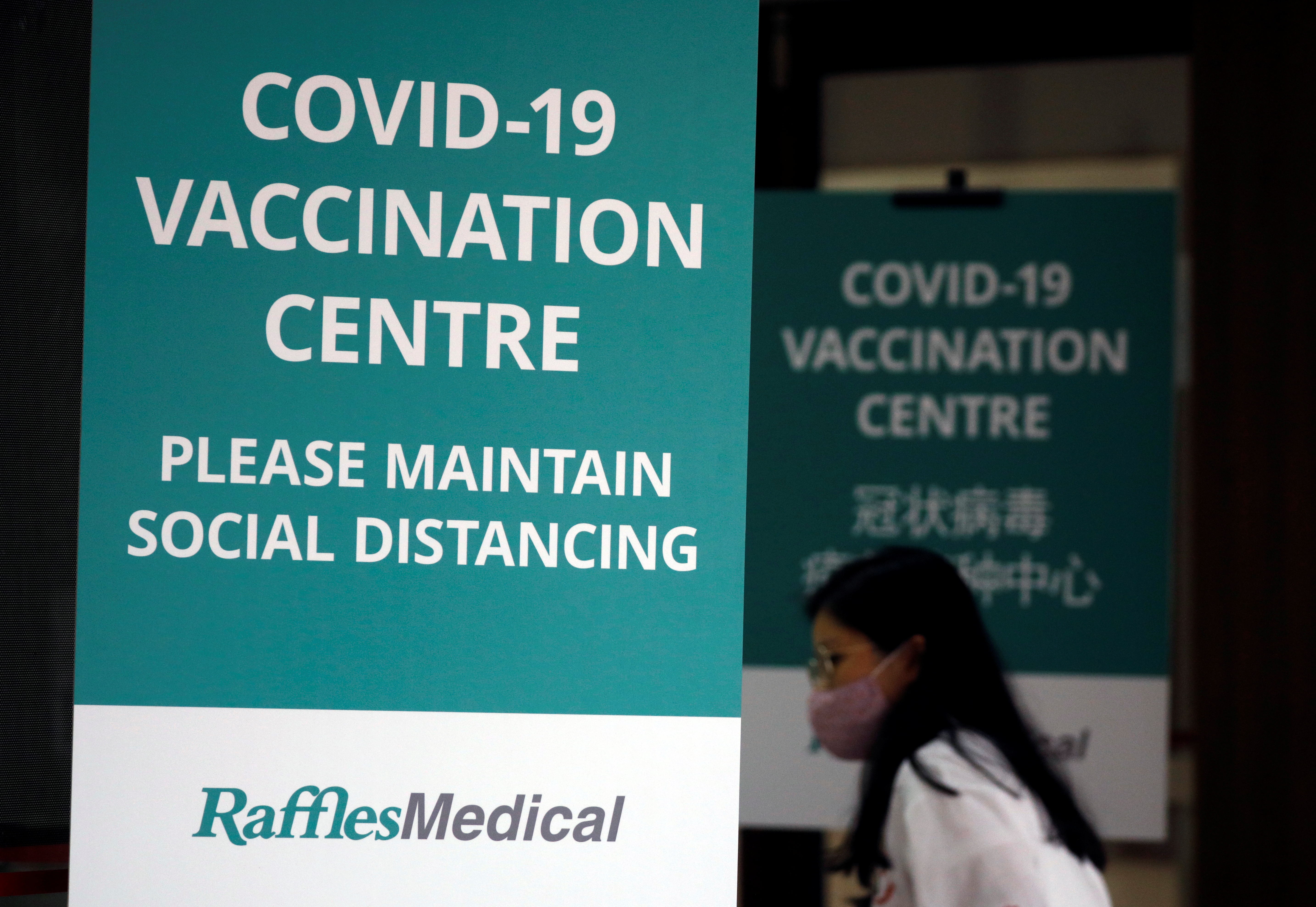A woman walks into a newly set up vaccination center which will be opened to the public the day after, in Singapore