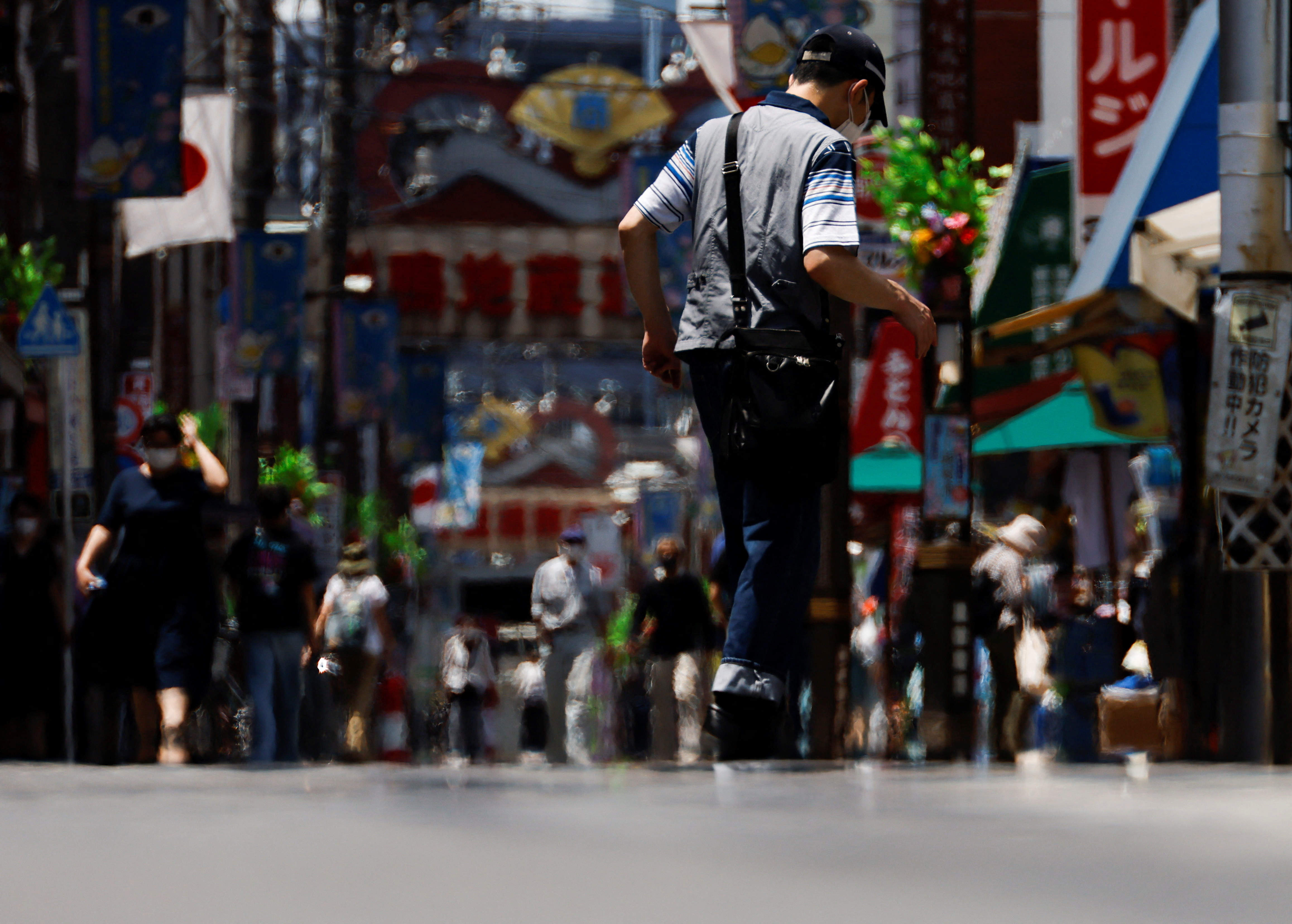 Passersby are seen through a heat haze during hot weather at Sugamo district in Tokyo