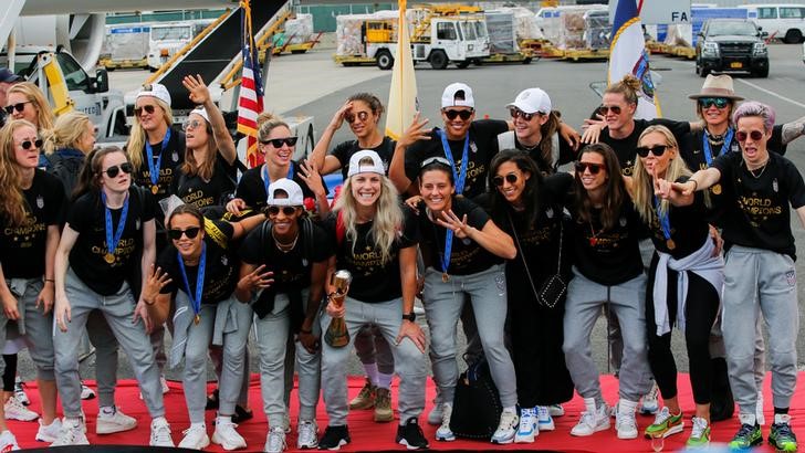 U.S. women soccer players pose for a picture with the Trophy for the FIFA Women's World Cup while the team arrive to the Newark International Airport, in Newark, New Jersey