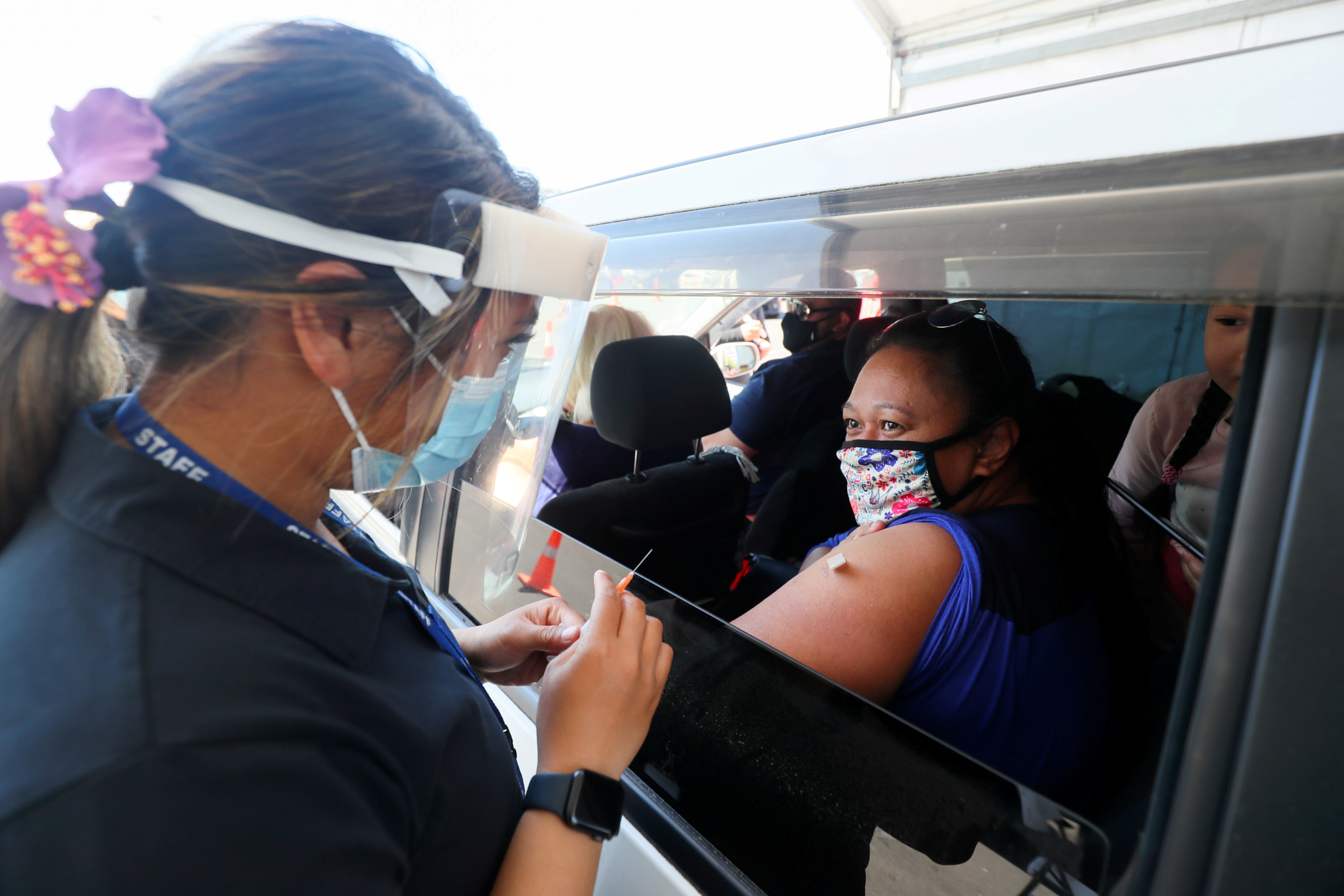 A member of the public receives a Pfizer vaccine at a drive-through coronavirus disease (COVID-19) vaccination clinic in Otara during a single-day vaccination drive, aimed at significantly increasing the percentage of vaccinated people in the country, in Auckland, New Zealand, October 16, 2021.  REUTERS/Simon Watts/File Photo
