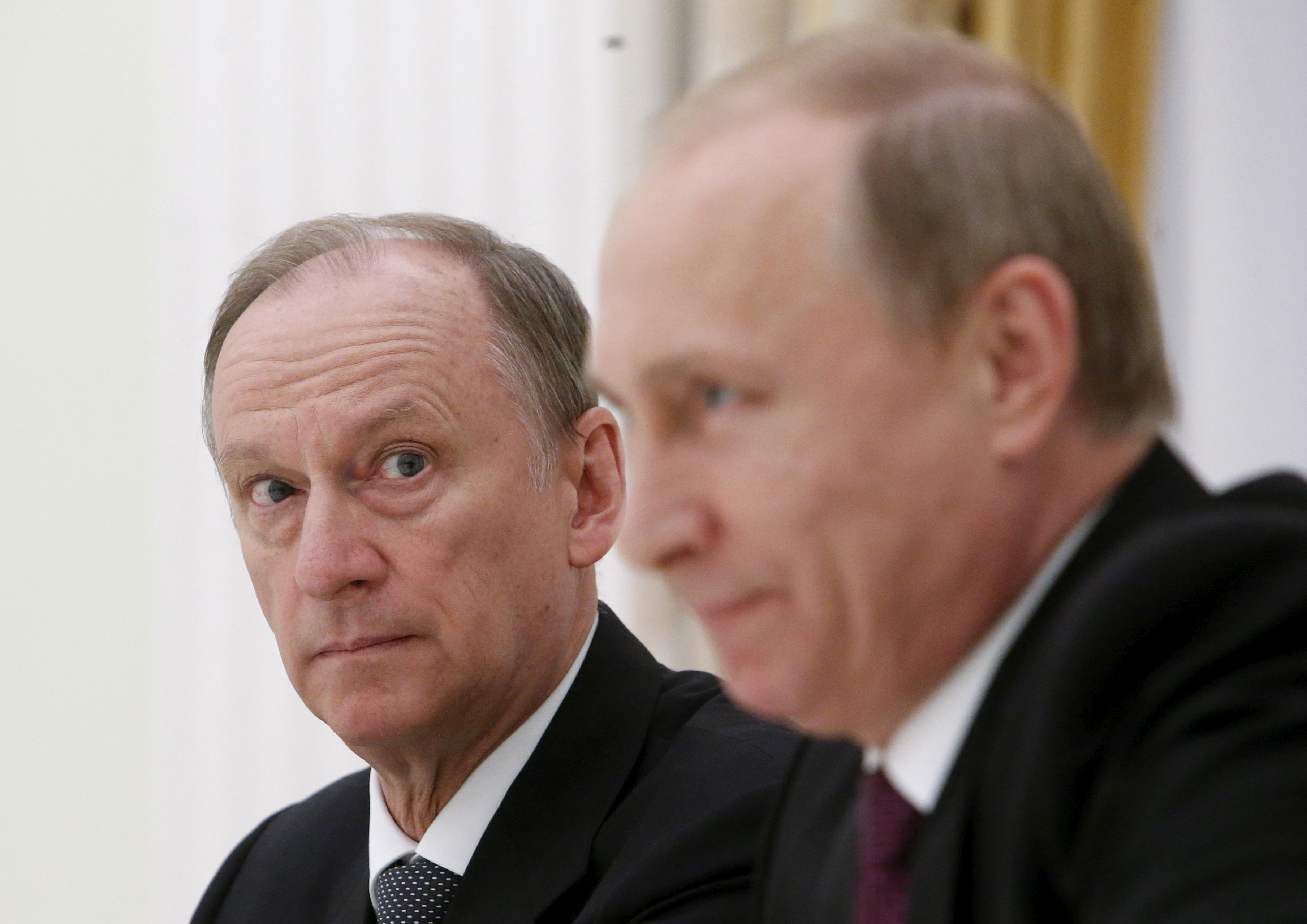 Russian Security Council Secretary Nikolai Patrushev (L) looks at President Vladimir Putin during a meeting with the BRICS countries' senior officials in charge of security matters at the Kremlin in Moscow
