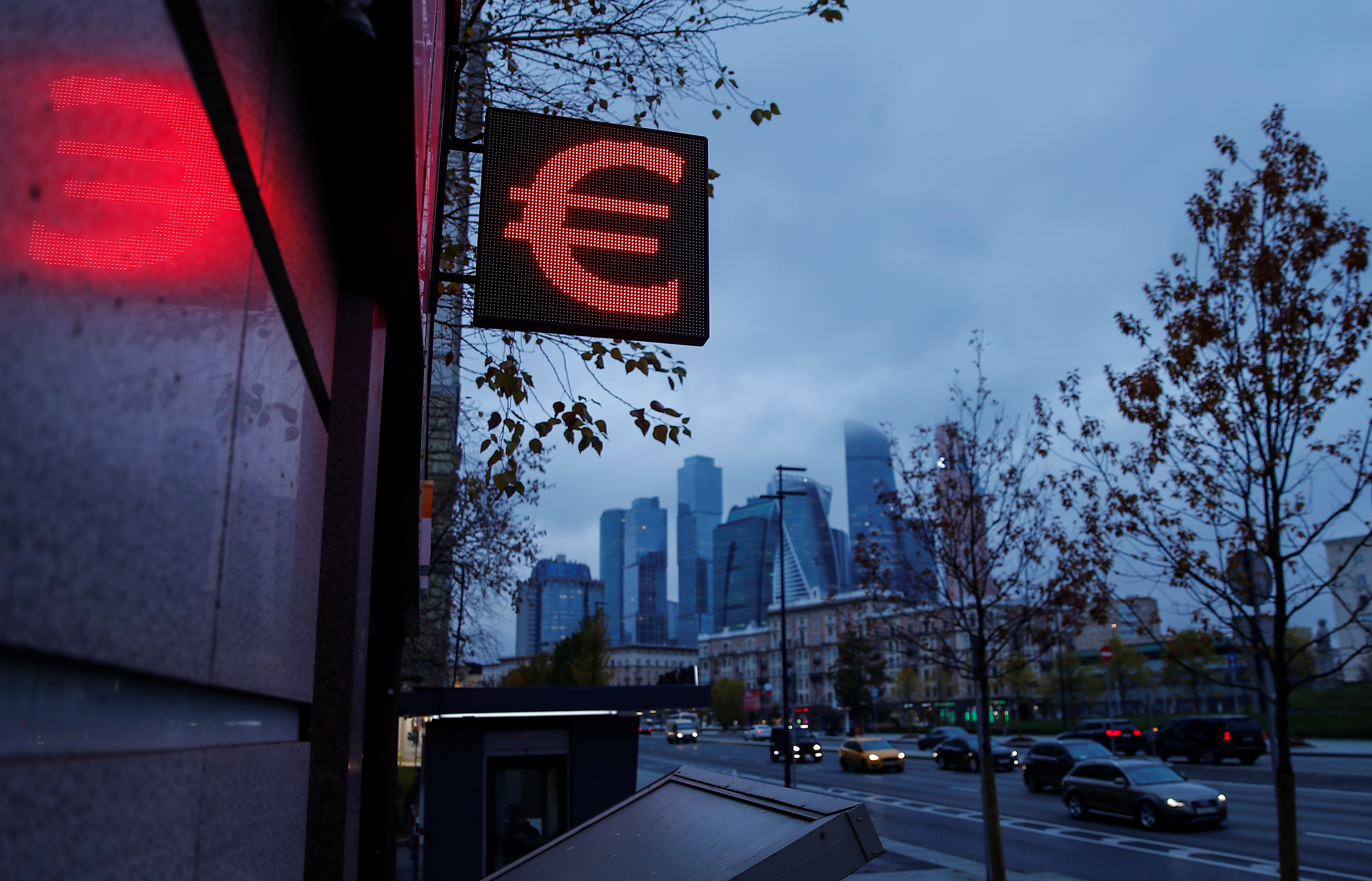 Advertisement board showing sign of the euro  is seen next to skyscrapers of Moskva-City businesss district in Moscow