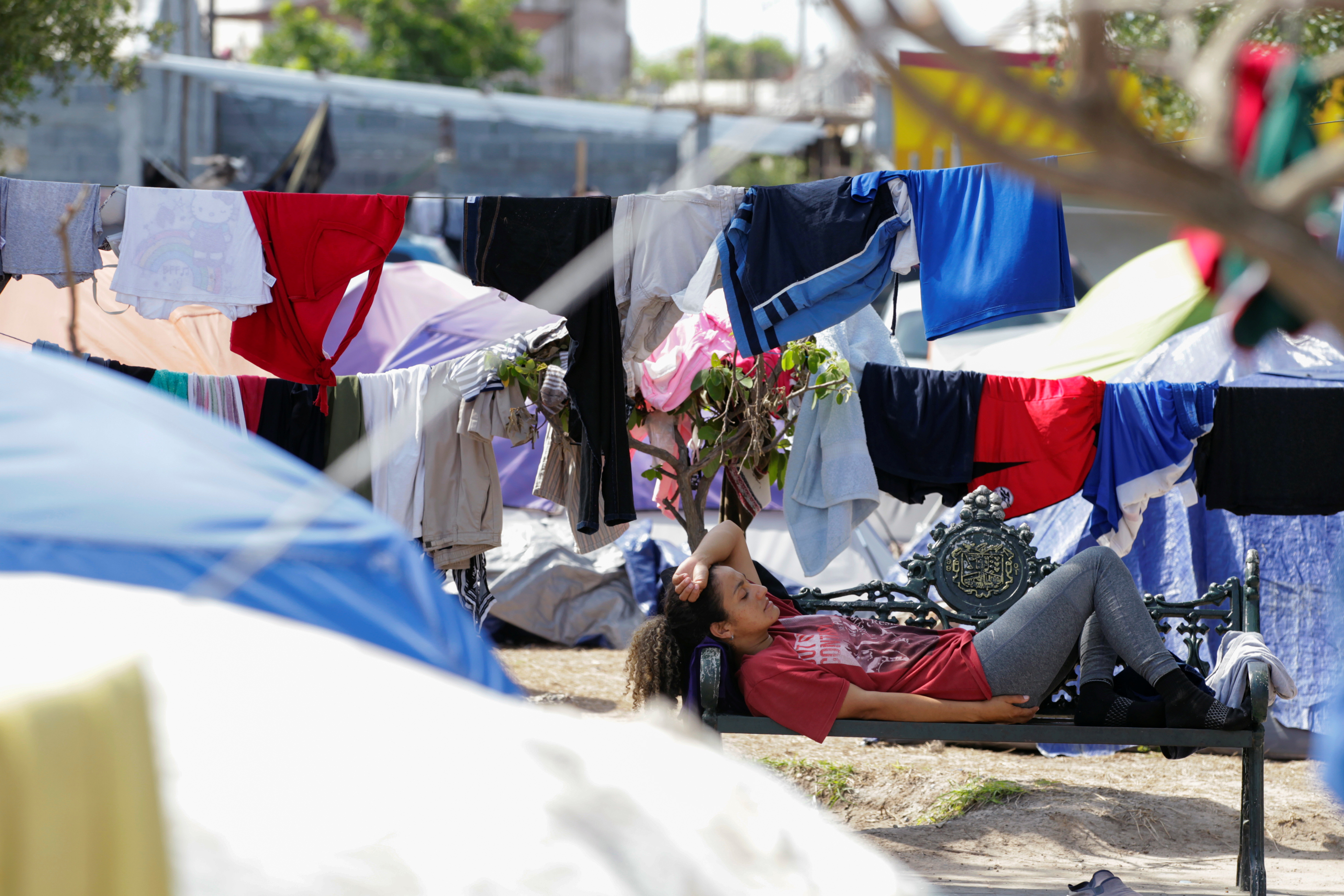 An asylum-seeking migrant, who was apprehended and returned to Mexico under Title 42 after crossing the border from Mexico into the U.S., rests in a public square where hundreds of migrants live in tents, in Reynosa, Mexico June 9, 2021. Picture taken June 9, 2021. REUTERS/Daniel Becerril