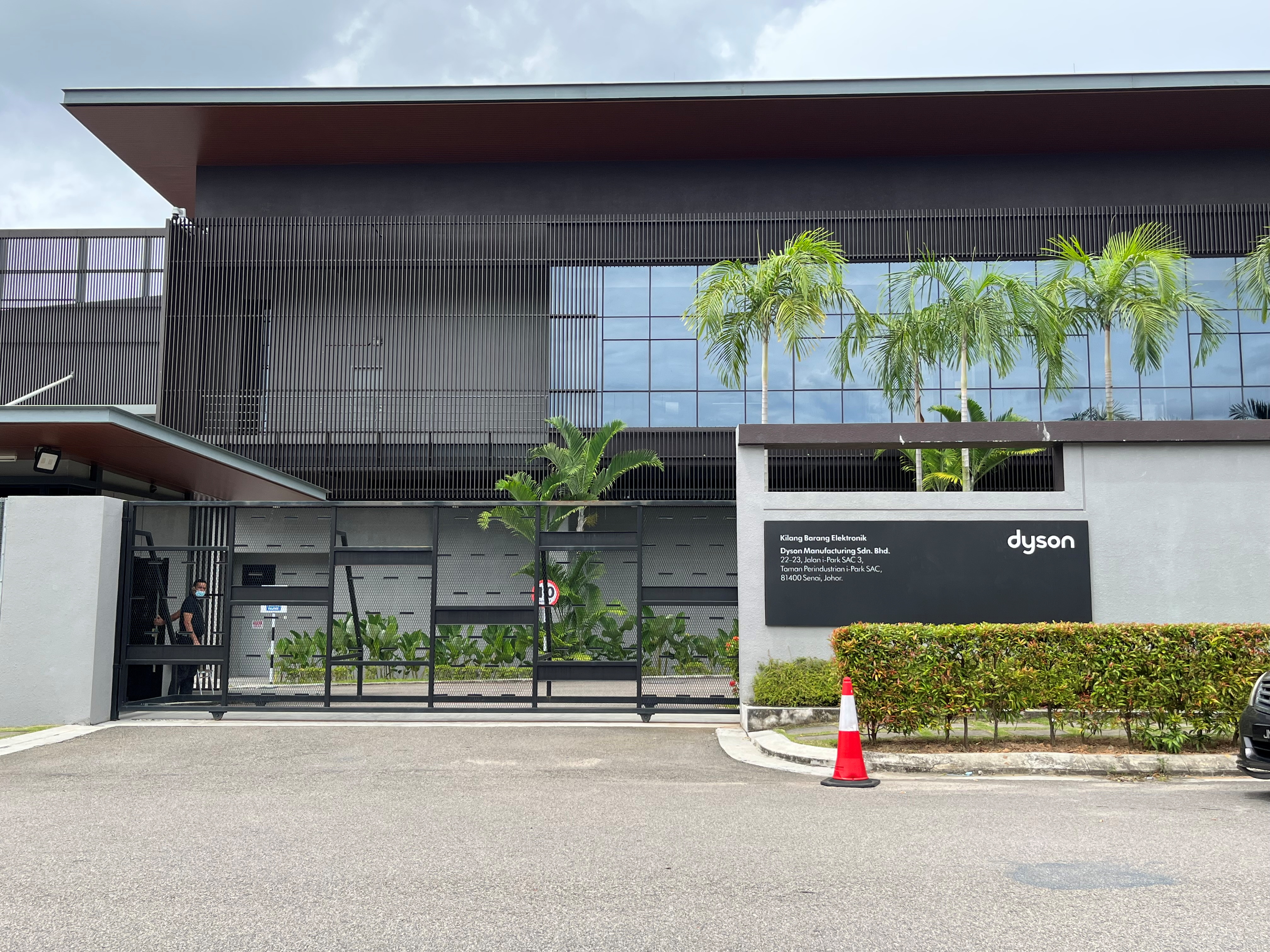 Security guard stands near the gate of Dyson office in Senai