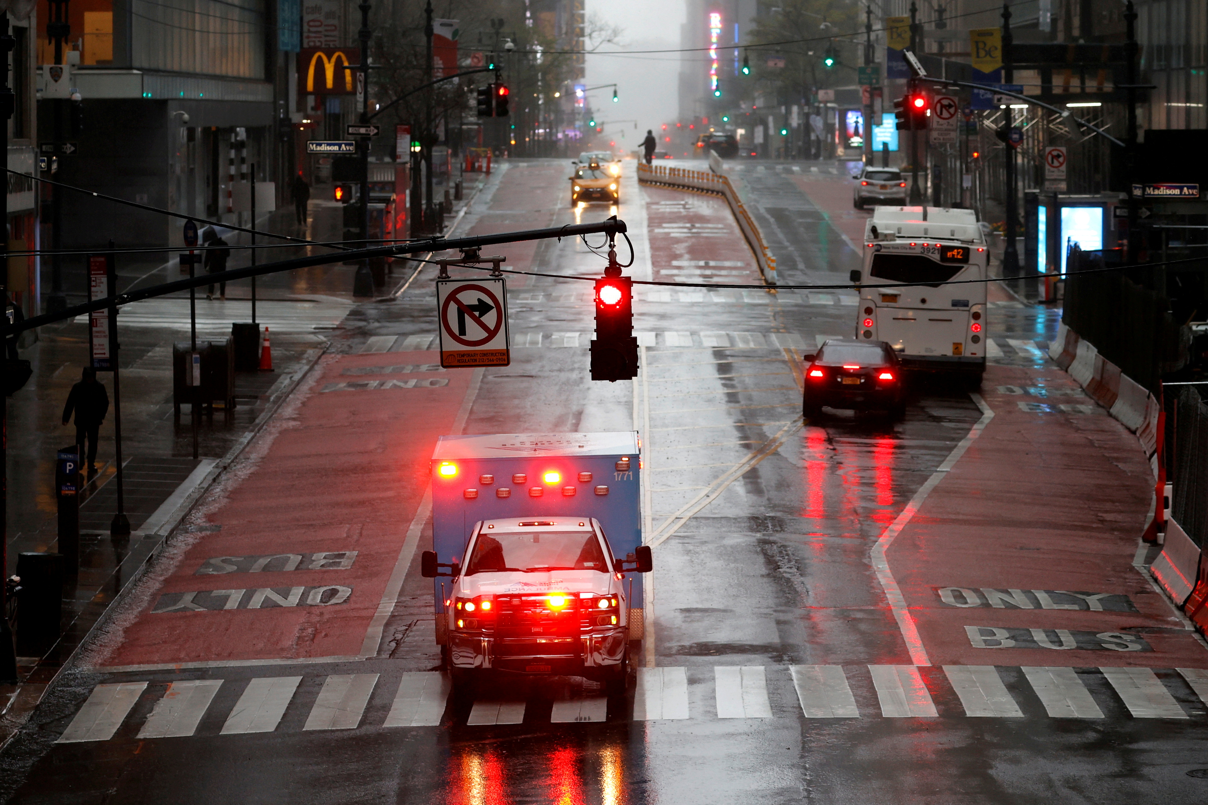 Ambulance in heavy rain and high winds across nearly empty East 42nd street during outbreak of coronavirus disease (COVID-19) in New York