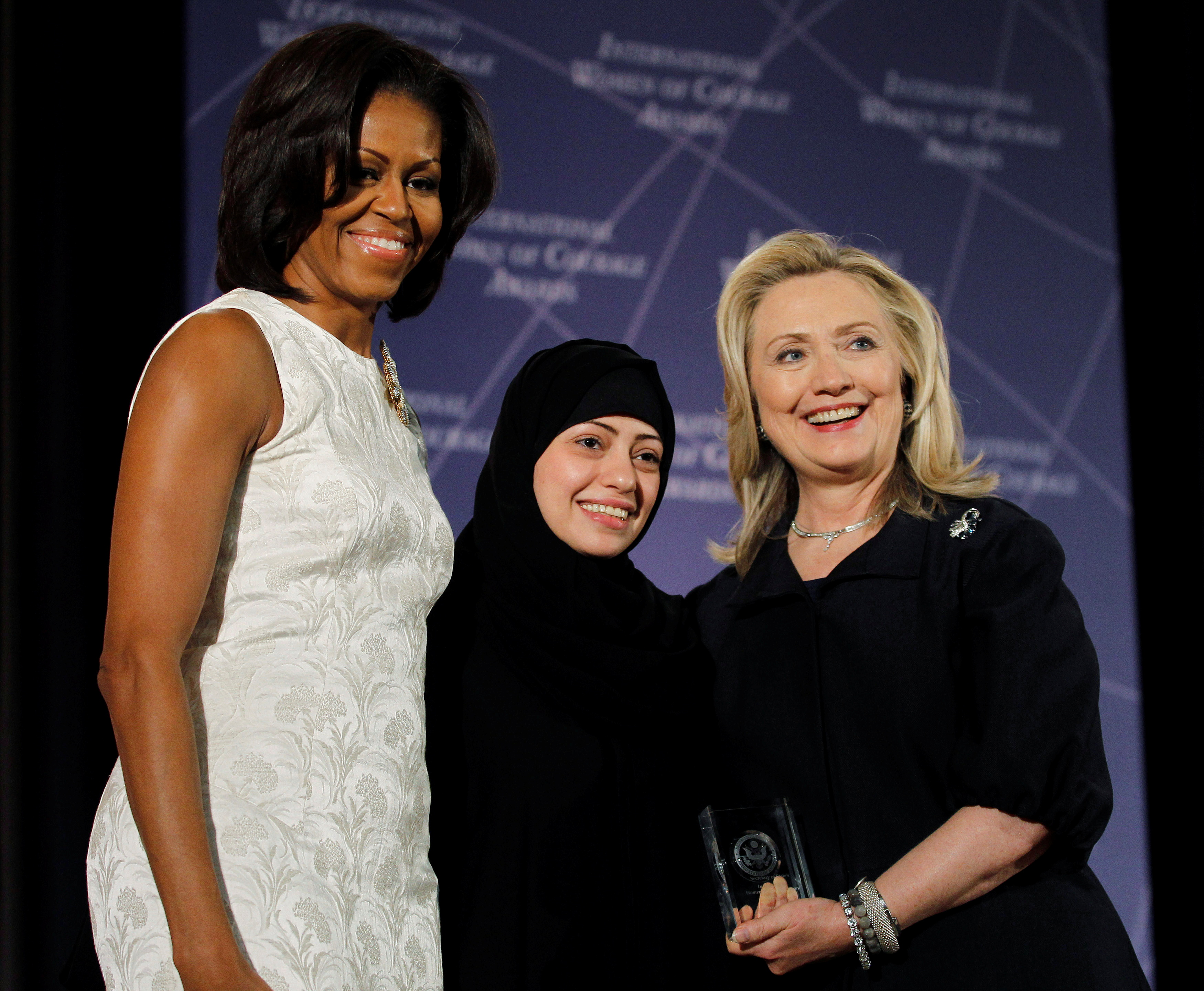 U.S. Secretary of State Hillary Clinton and First lady Michelle Obama congratulate Samar Badawi of Saudi Arabia in Washington