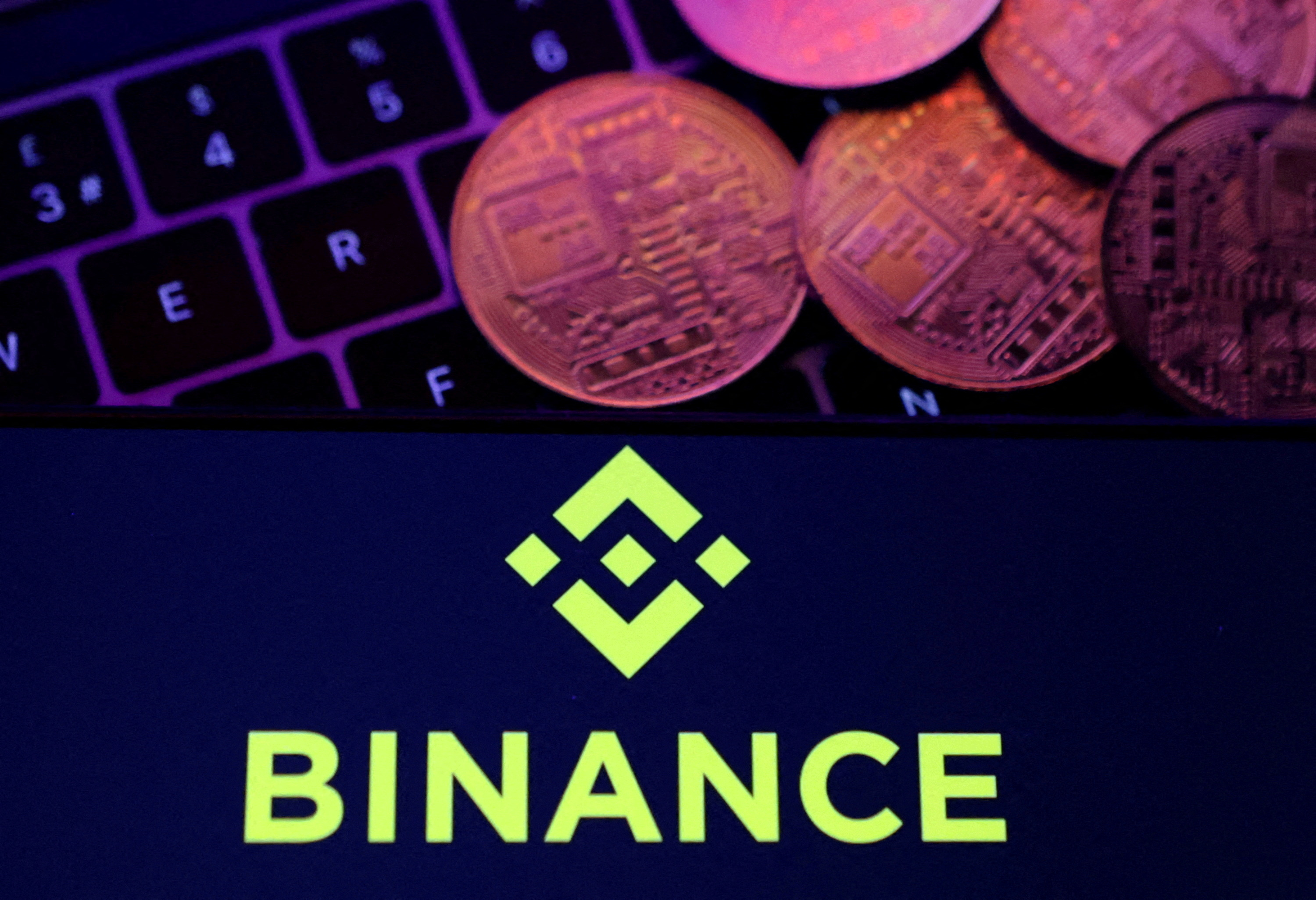Ilustracija prikazuje logotip Binance i prikaz kriptovalute