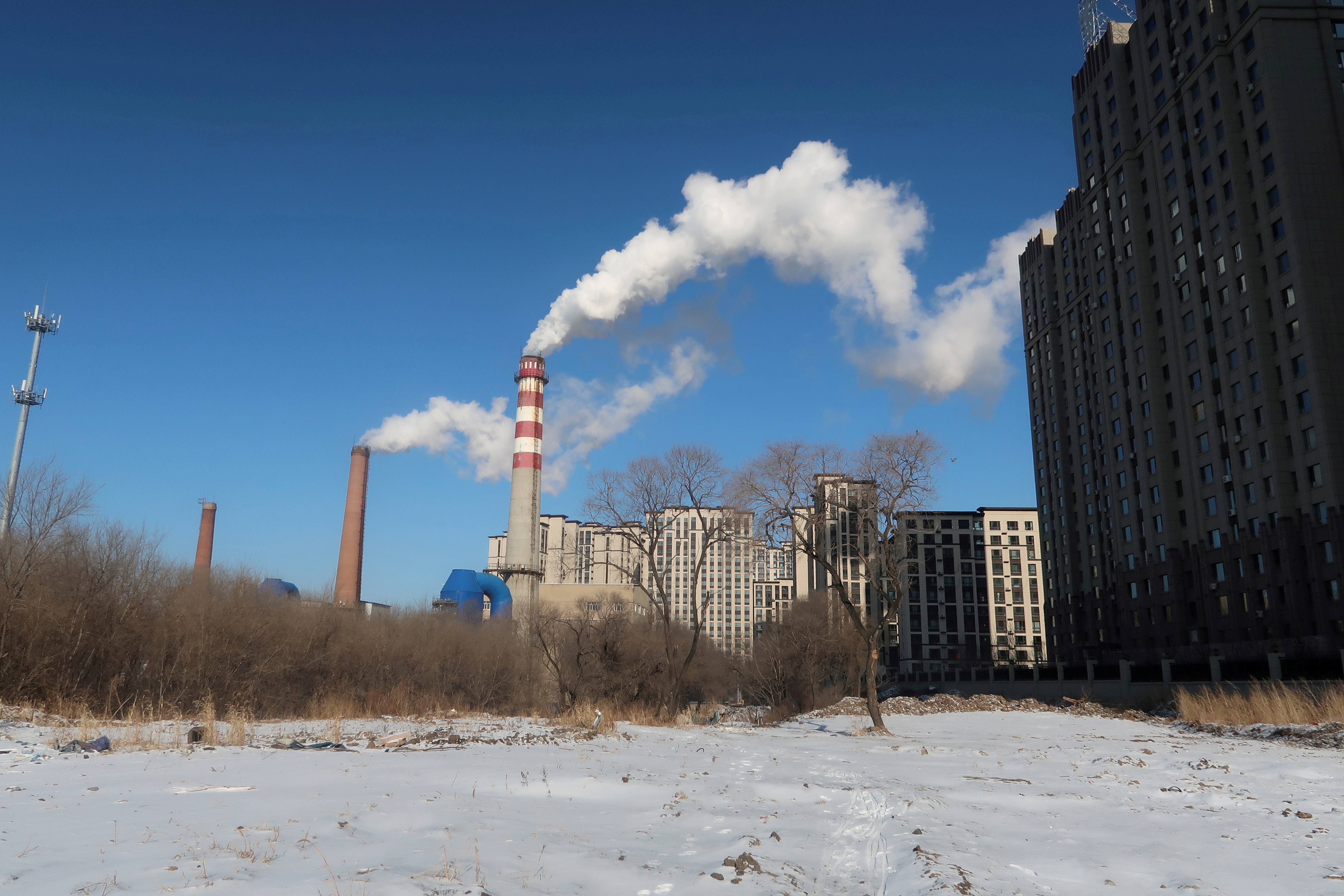 A coal-fired heating complex is seen behind the ground covered by snow in Harbin