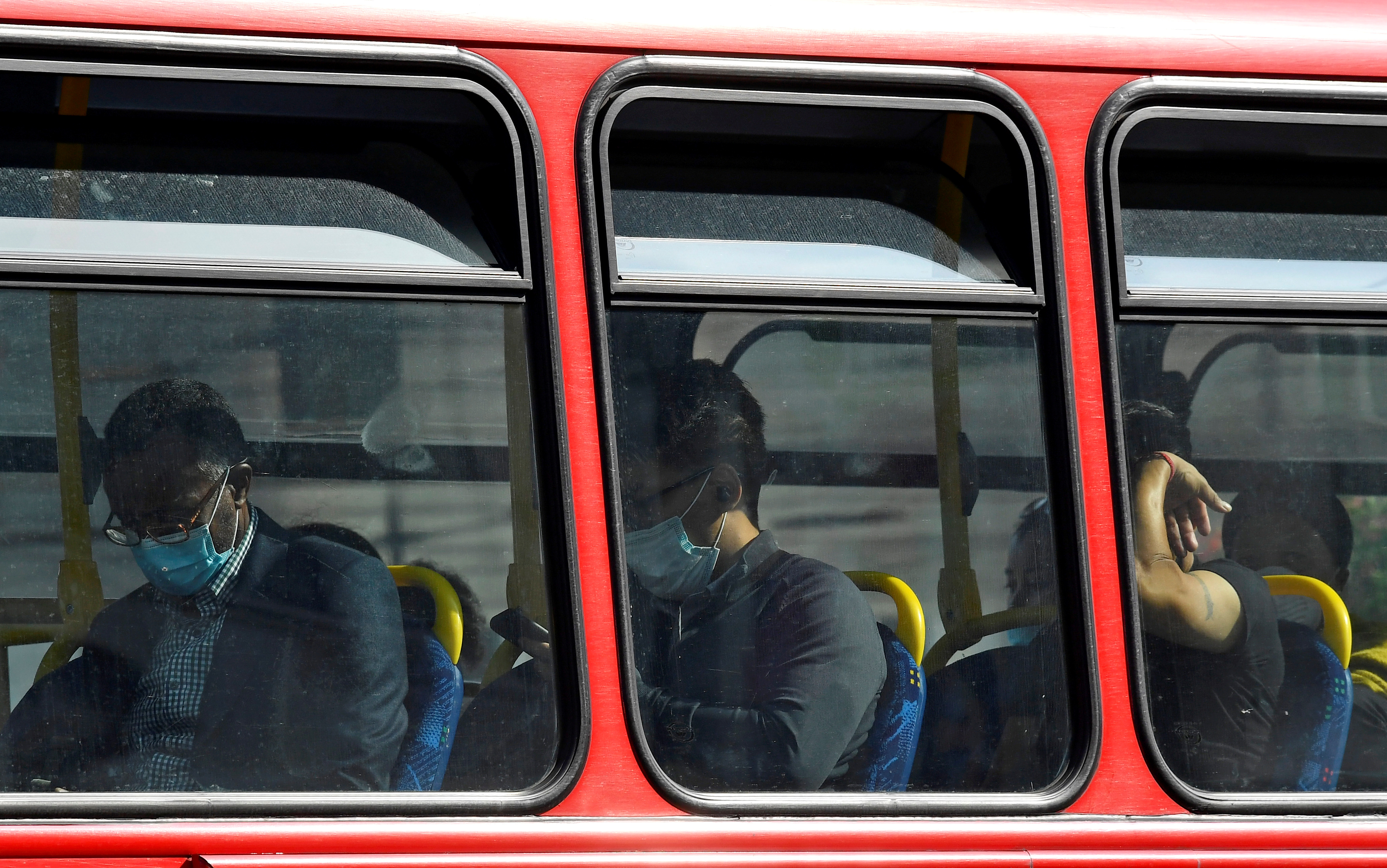 Passengers wear protective face coverings on a London bus, whilst the reproduction 