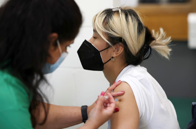 A person receives a dose of the Pfizer BioNTech vaccine at a vaccination centre for those aged over 18 at the Belmont Health Centre in Harrow, amid the coronavirus disease (COVID-19) outbreak in London
