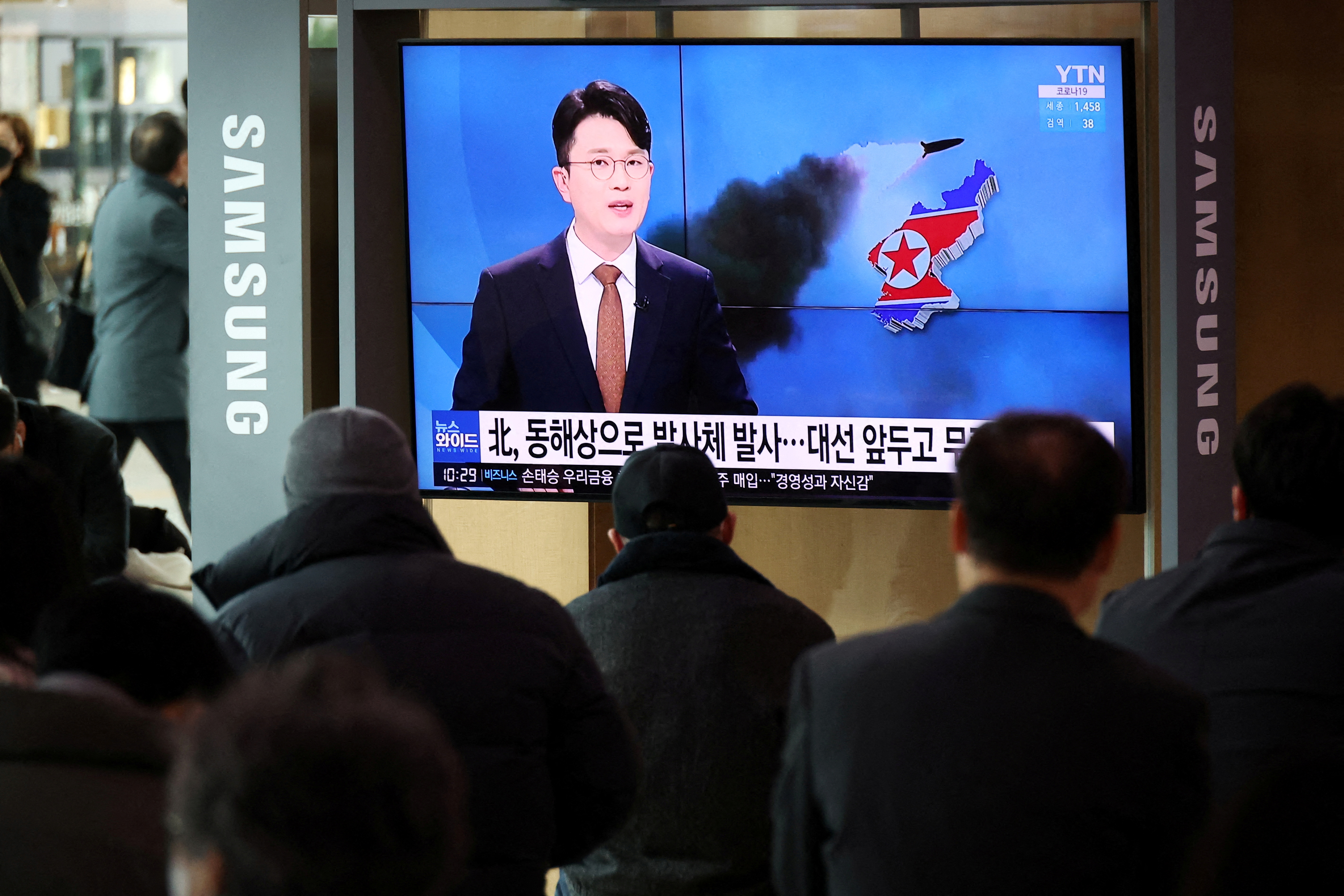 People watch a TV broadcasting a news report on North Korea's firing a ballistic missile off its east coast, in Seoul