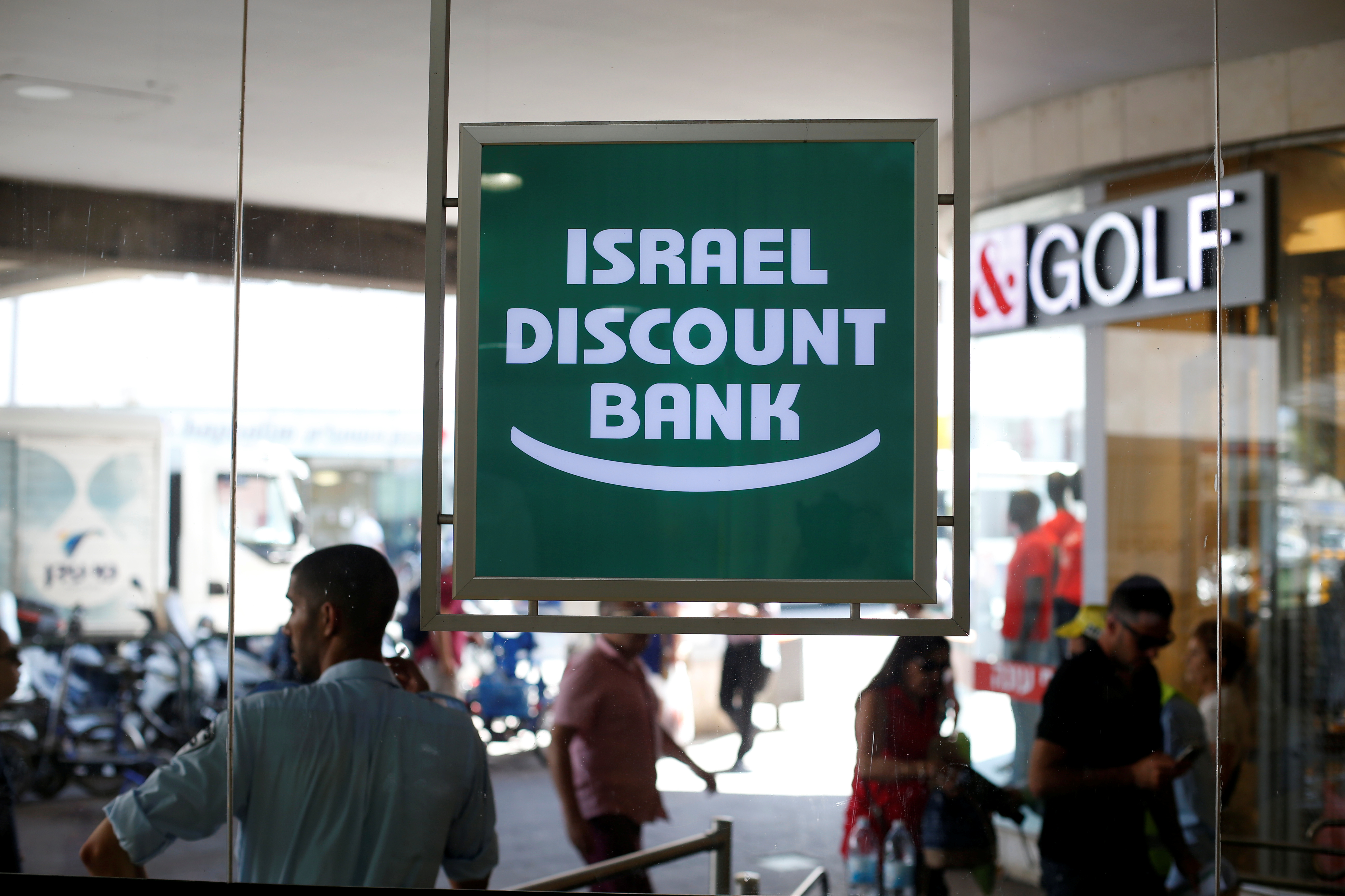 The logo of Israel Discount Bank is reflected in mirrors outside their branch in Tel Aviv, Israel