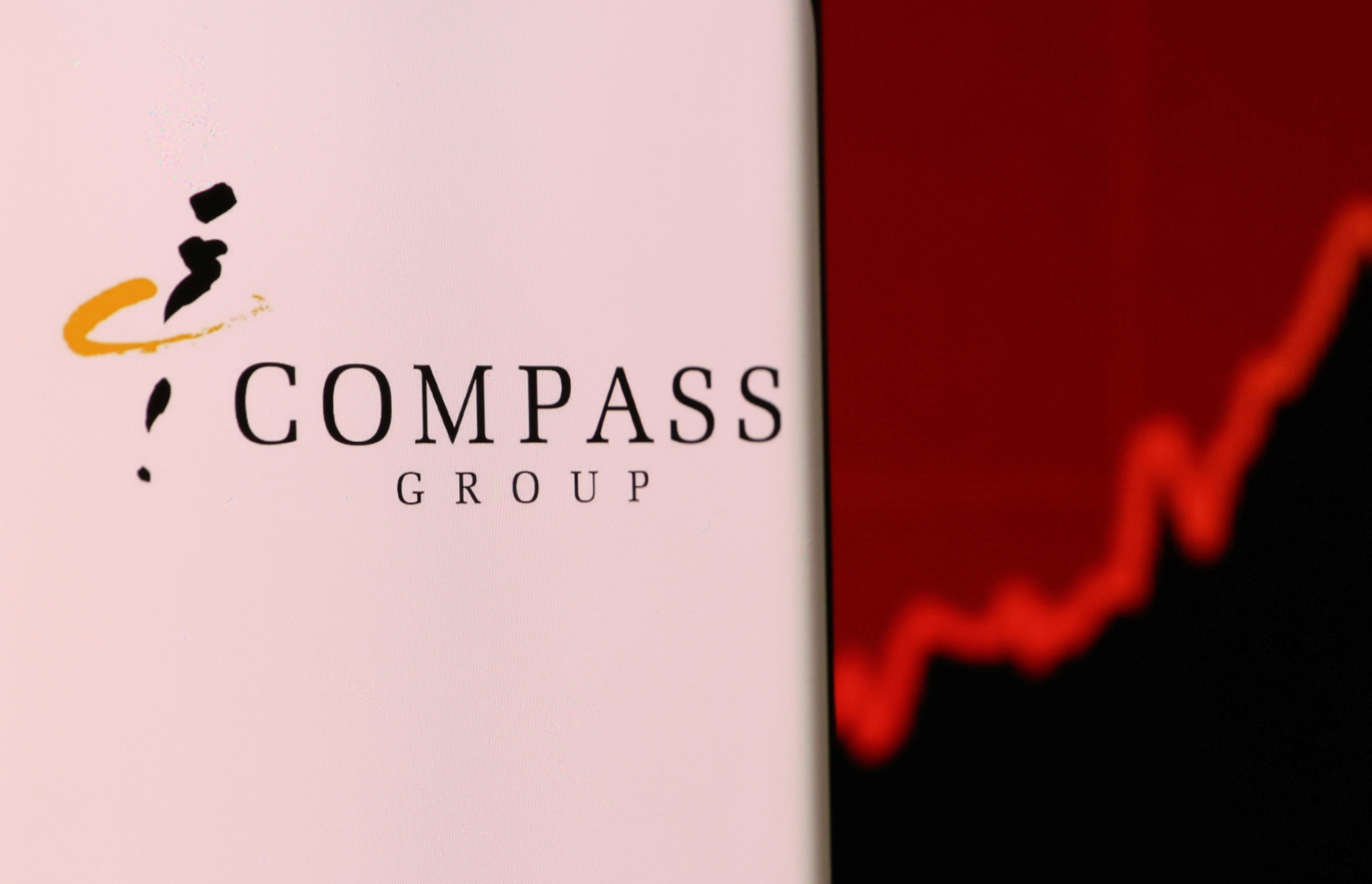 Illustration shows smartphone with Compass Group's logo displayed