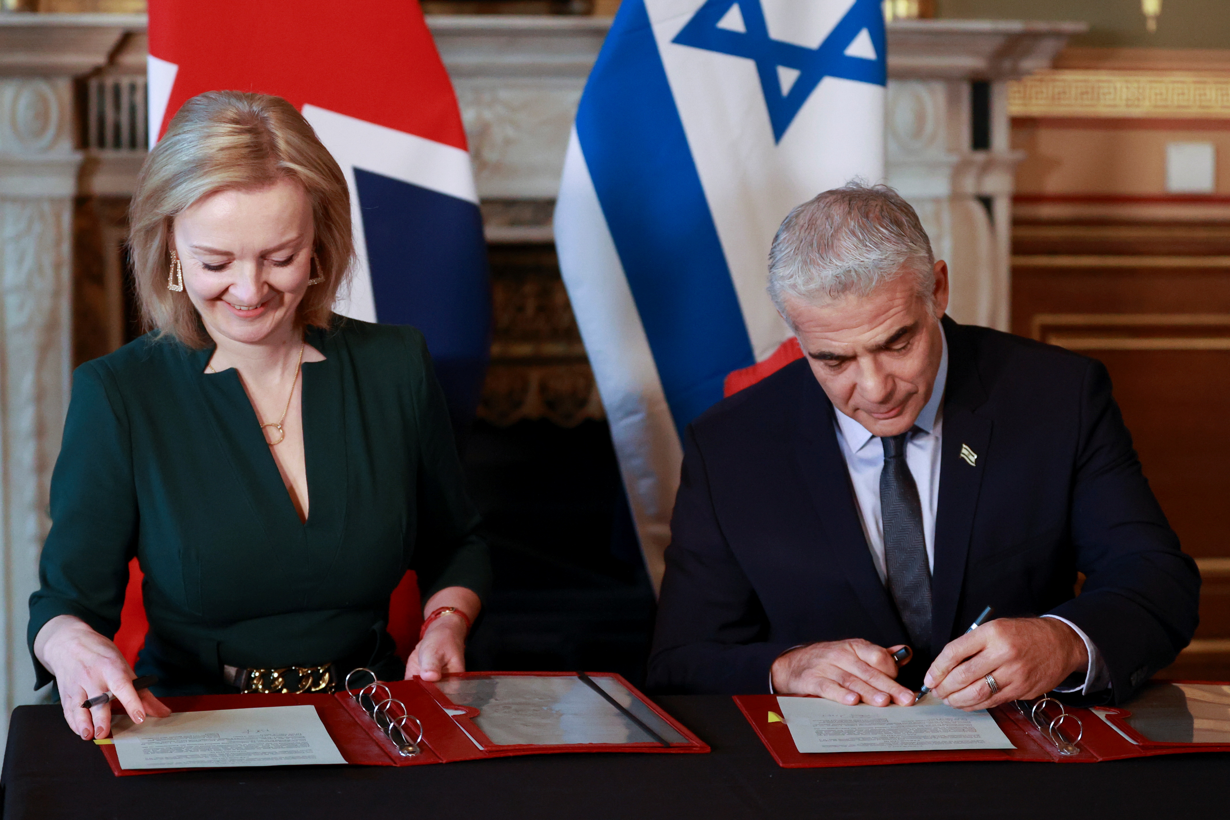 Britain's Foreign Secretary Liz Truss and Israeli Foreign Minister Yair Lapid sign a memorandum of understanding at Britain's Foreign Commonwealth & Development Office in London, Britain, November 29, 2021. REUTERS/Hannah McKay