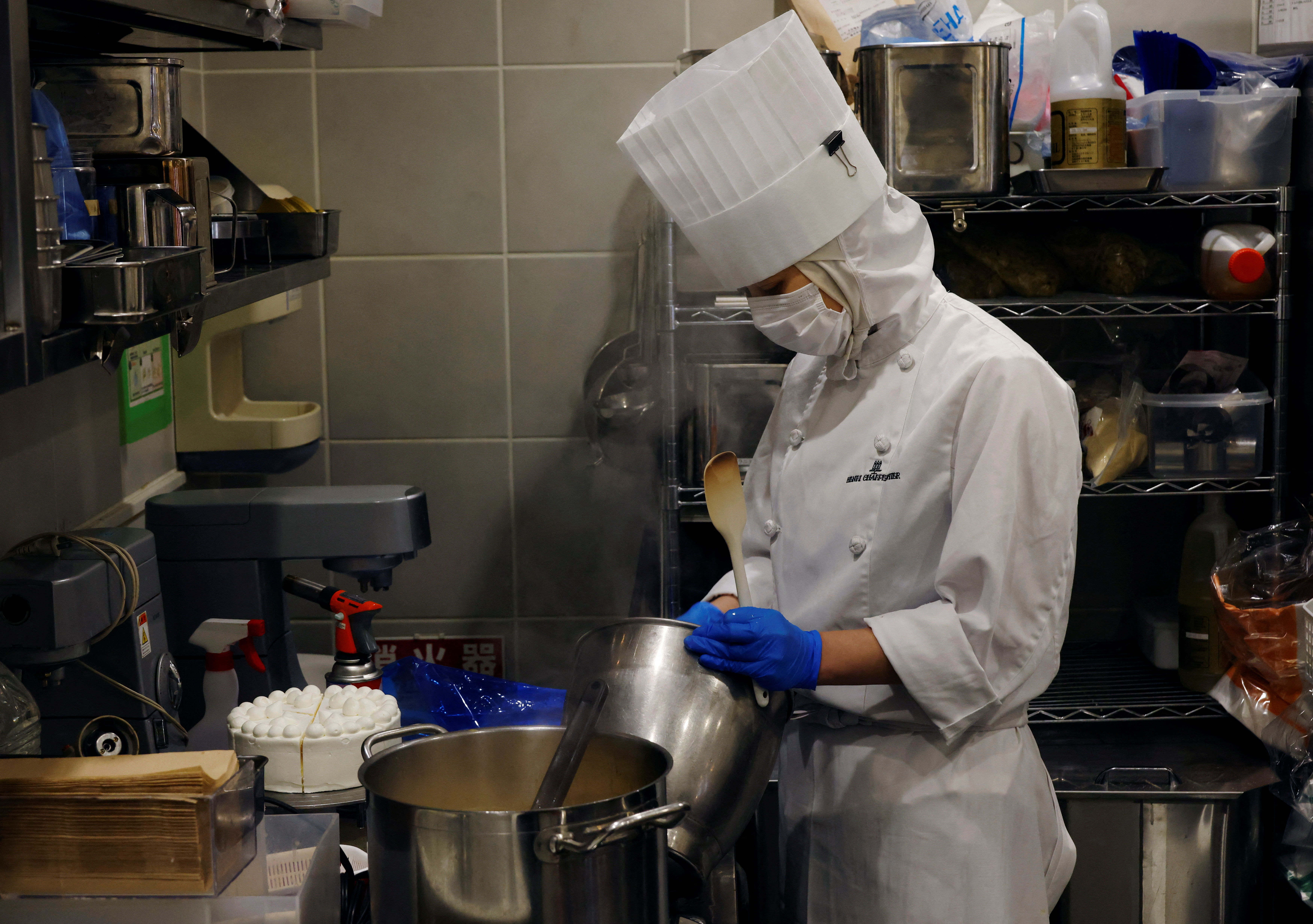 An employee of Suzette Holdings Co. prepares cakes at the shop in Tokyo