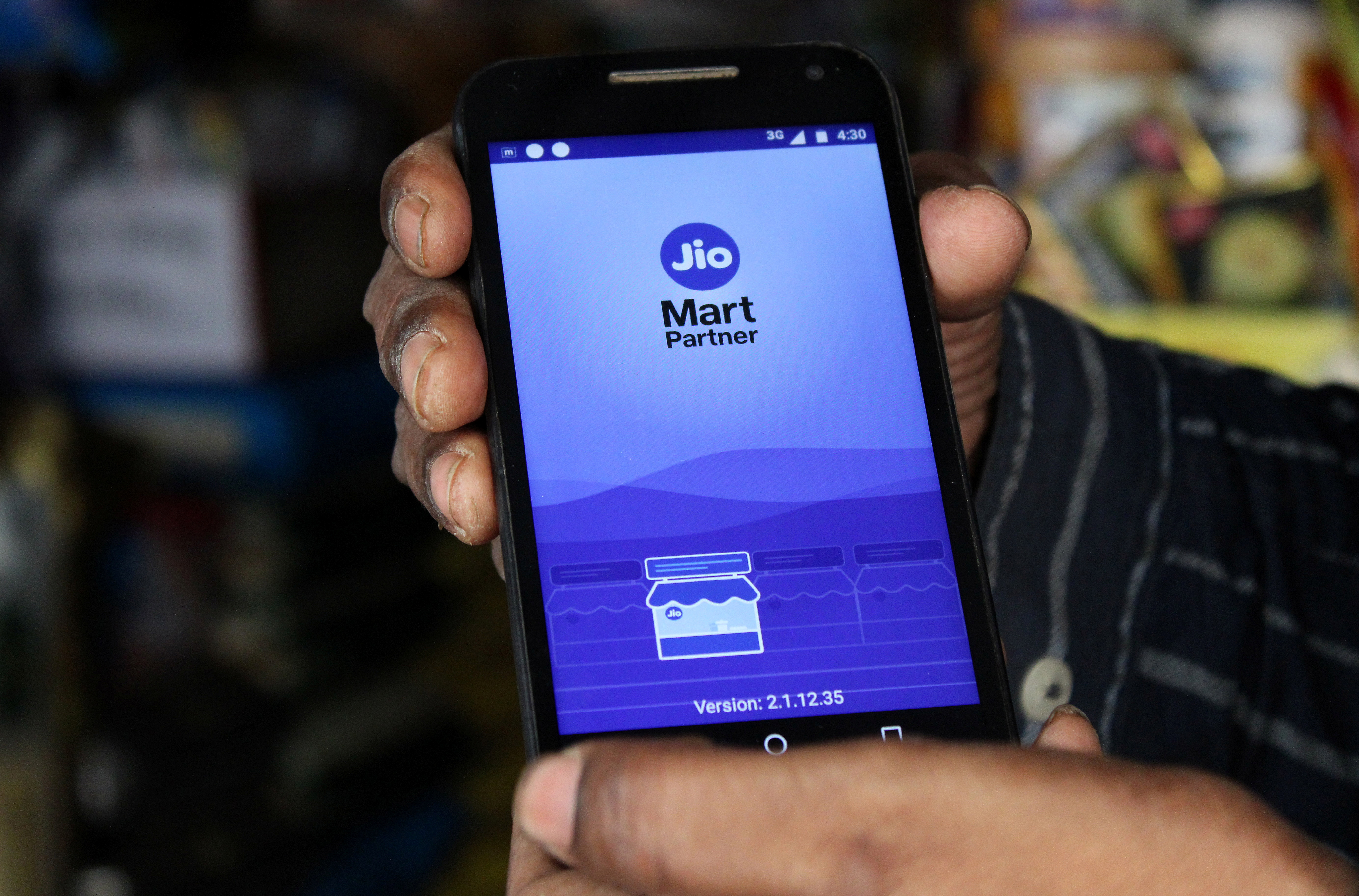 A shopkeeper selling consumer goods shows Reliance's JioMart Partner app on his mobile phone that he uses to order supplies for his store in Sangli, in the western state of Maharashtra, India, October 21, 2021. REUTERS/Abhirup Roy