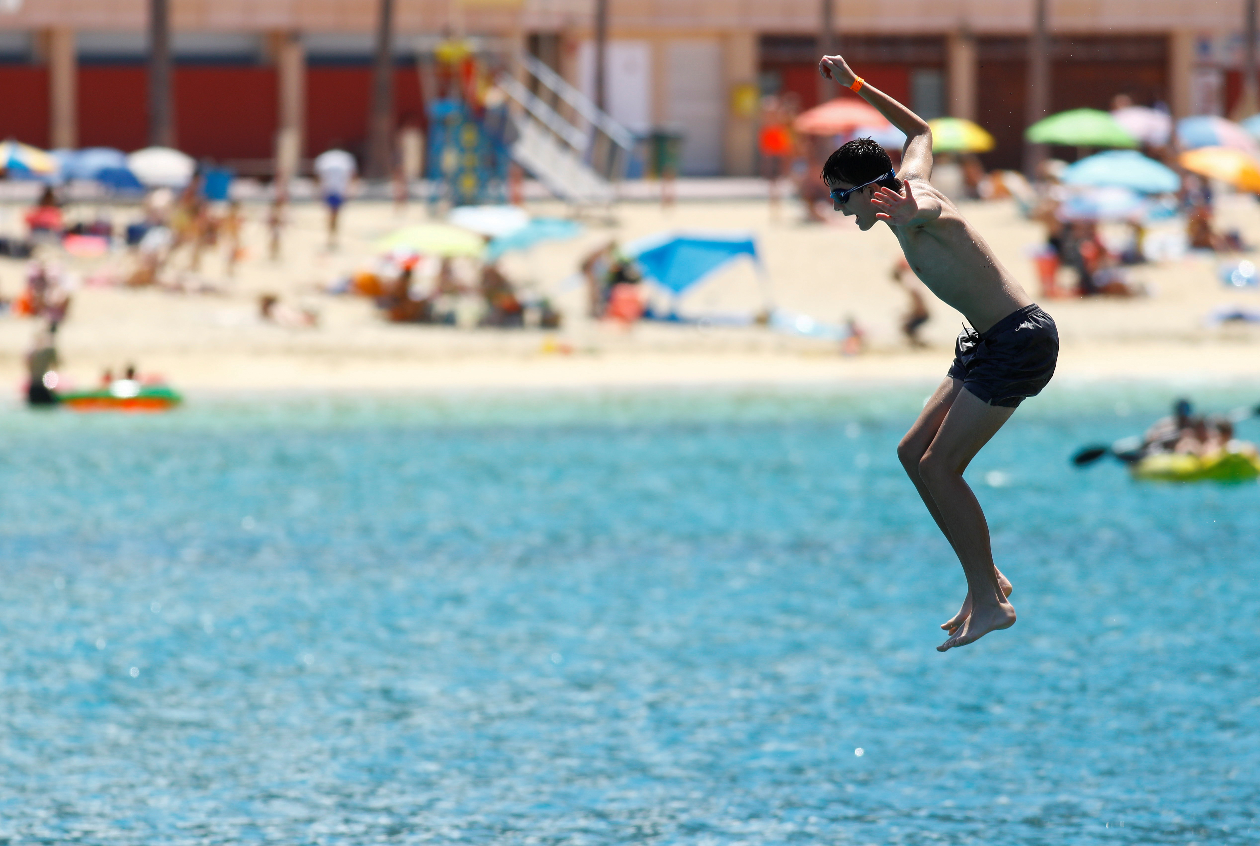 A tourist jumps into the sea on the Amadores beach, amid the outbreak of the coronavirus disease (COVID-19) in the south of the island of Gran Canaria