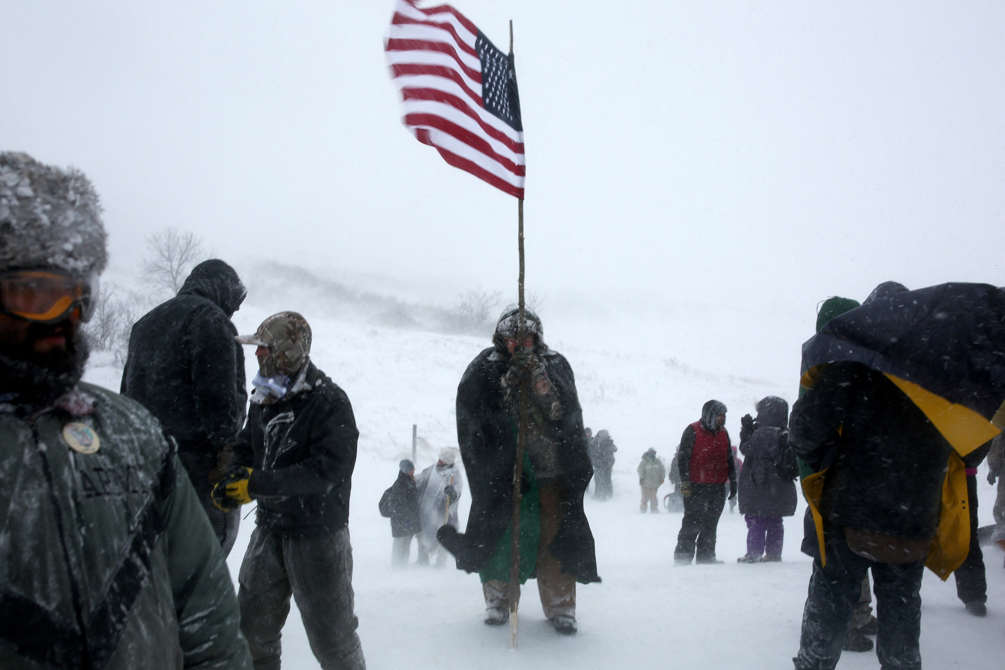 A man holds an American flag while protesting near Standing Rock Indian Reservation, North Dakota