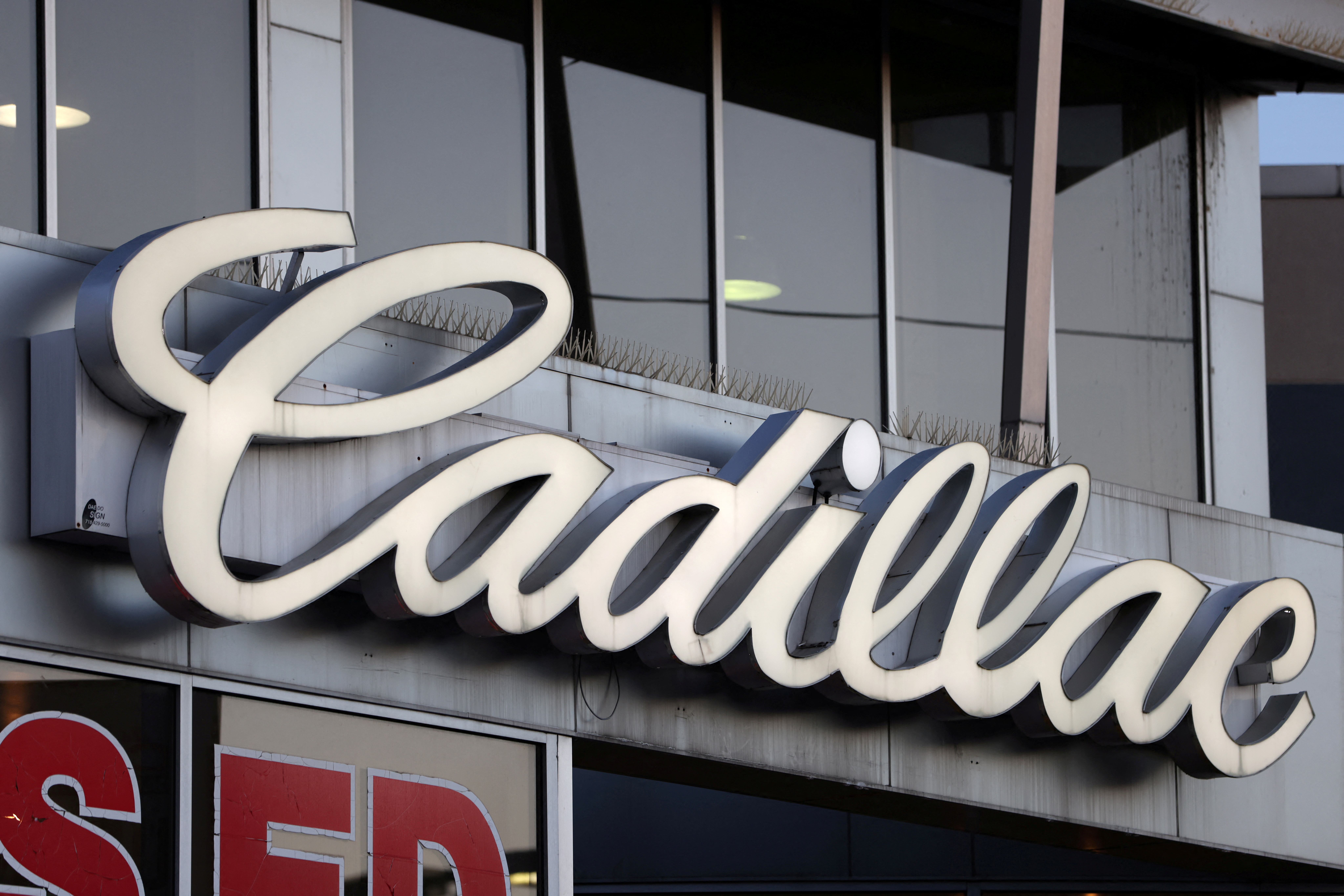 Signage for Cadillac, an automobile brand owned by General Motors Company, is seen at a car dealership in Queens, New York